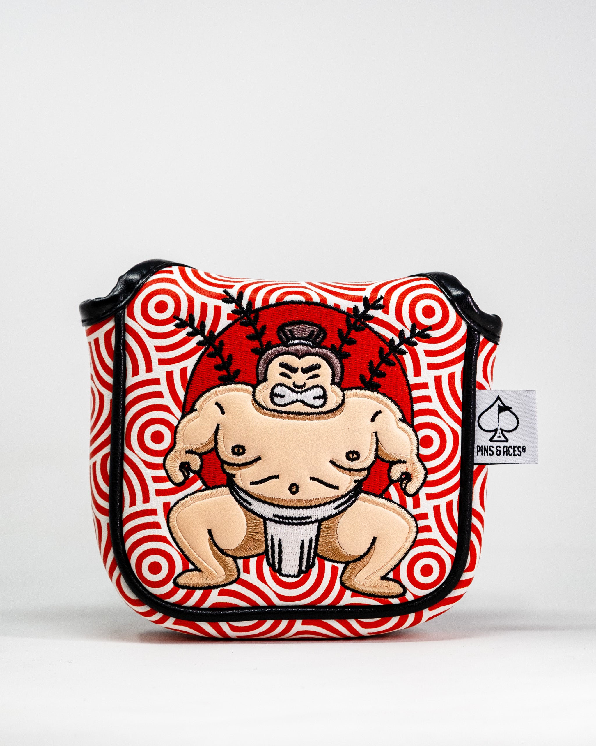 Sumo wrestler embroidered patch on a red and white patterned golf mallet putter cover with black trim and a Pins and Aces tag.