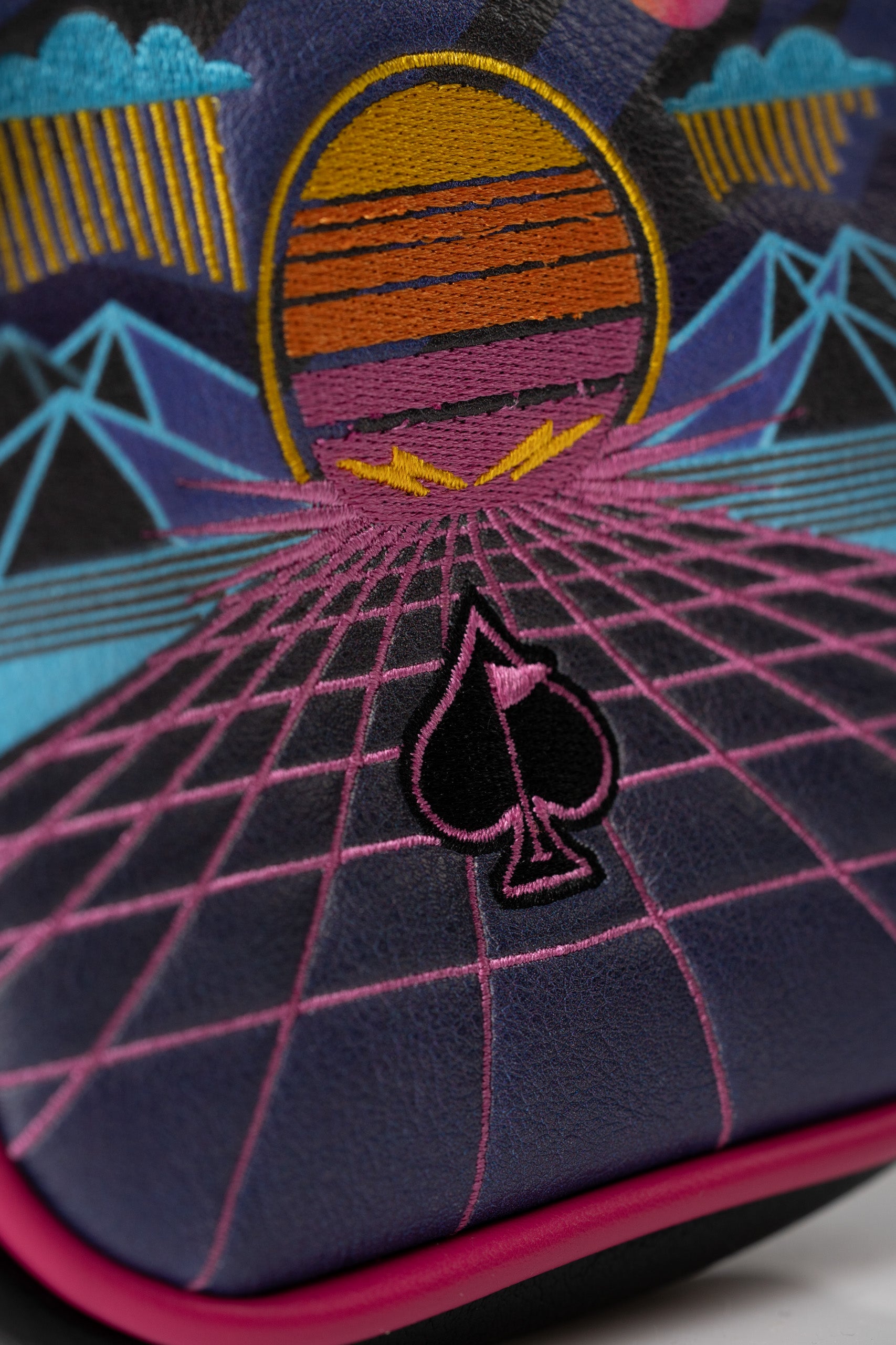 Bold mallet putter cover featuring a vibrant synthwave design with geometric patterns and a spade logo. Perfect for stylish golfers.