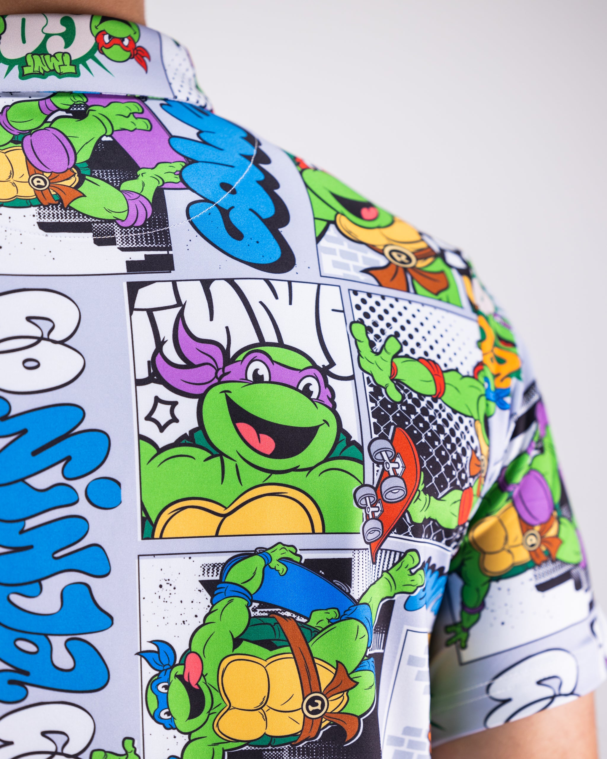 TMNT comic strip polo shirt featuring colorful prints of Teenage Mutant Ninja Turtles in action.