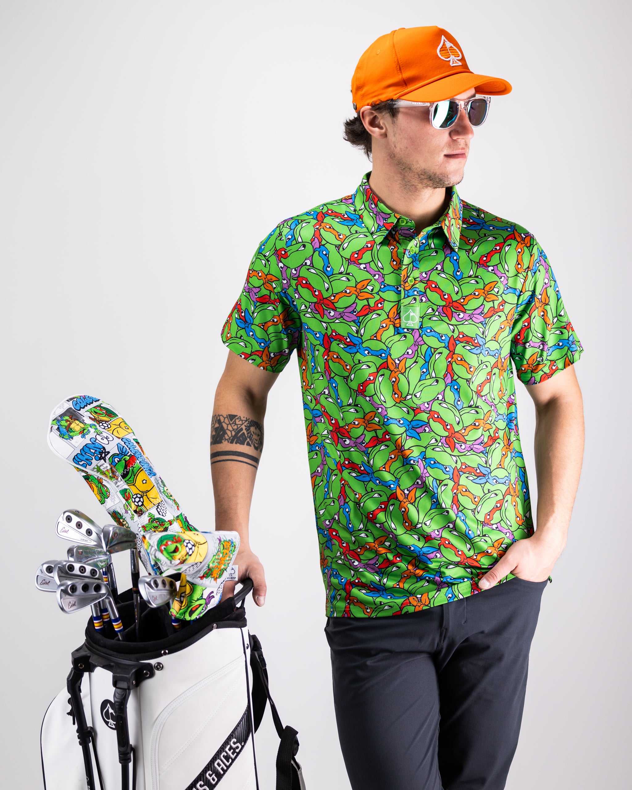 Alt text: "TMNT Mean Green Polo featuring turtle head designs, vibrant green color, perfect for Teenage Mutant Ninja Turtles fans."