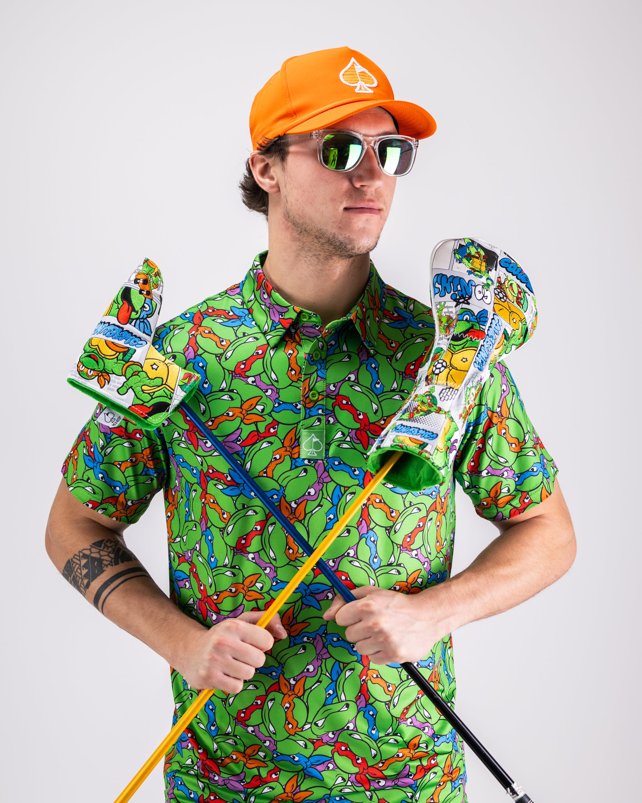 TMNT Mean Green polo shirt featuring colorful turtle head graphics on a vibrant green background.