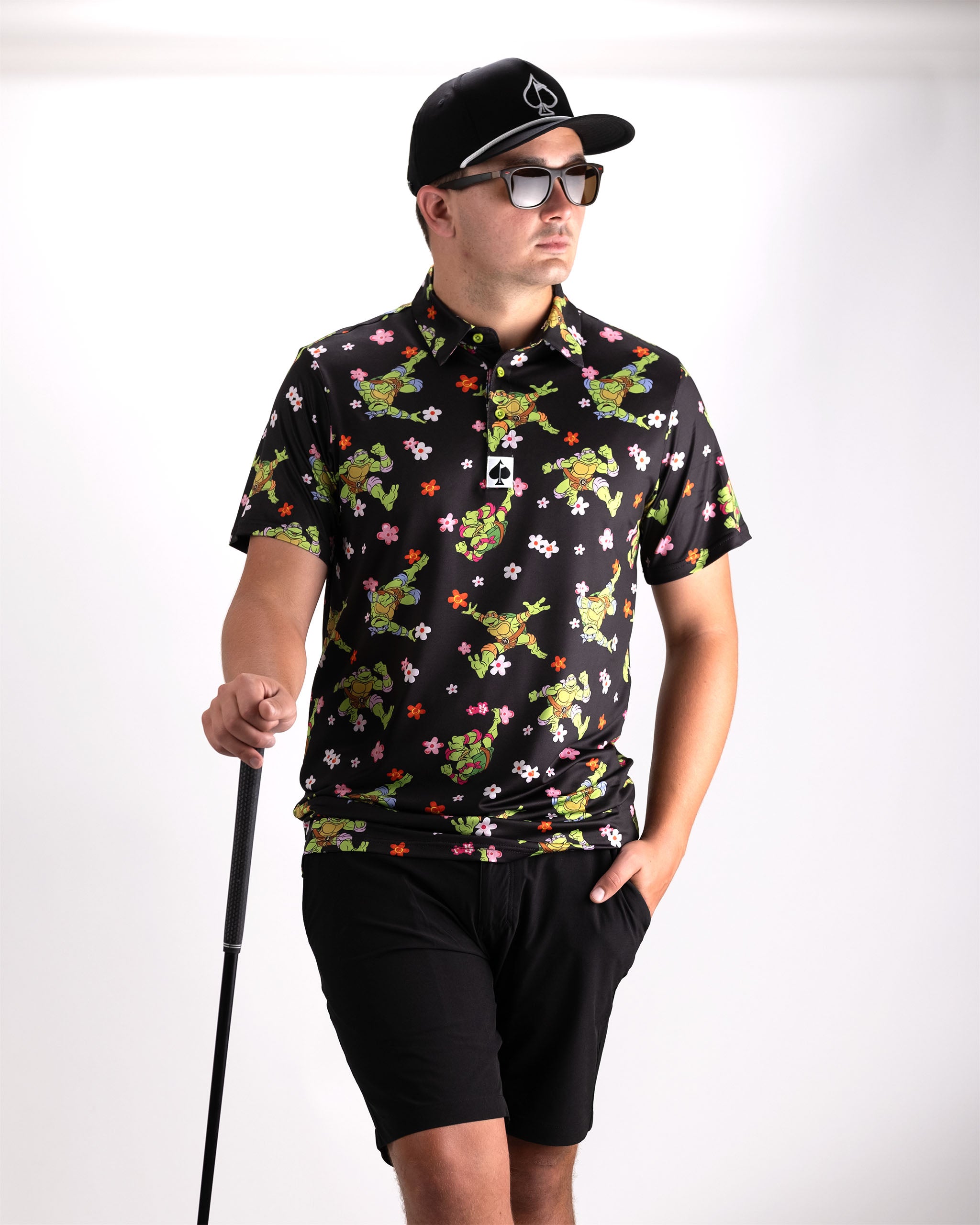 TMNT Turtle Flower Power polo shirt featuring colorful turtle graphics and floral designs on a vibrant background.
