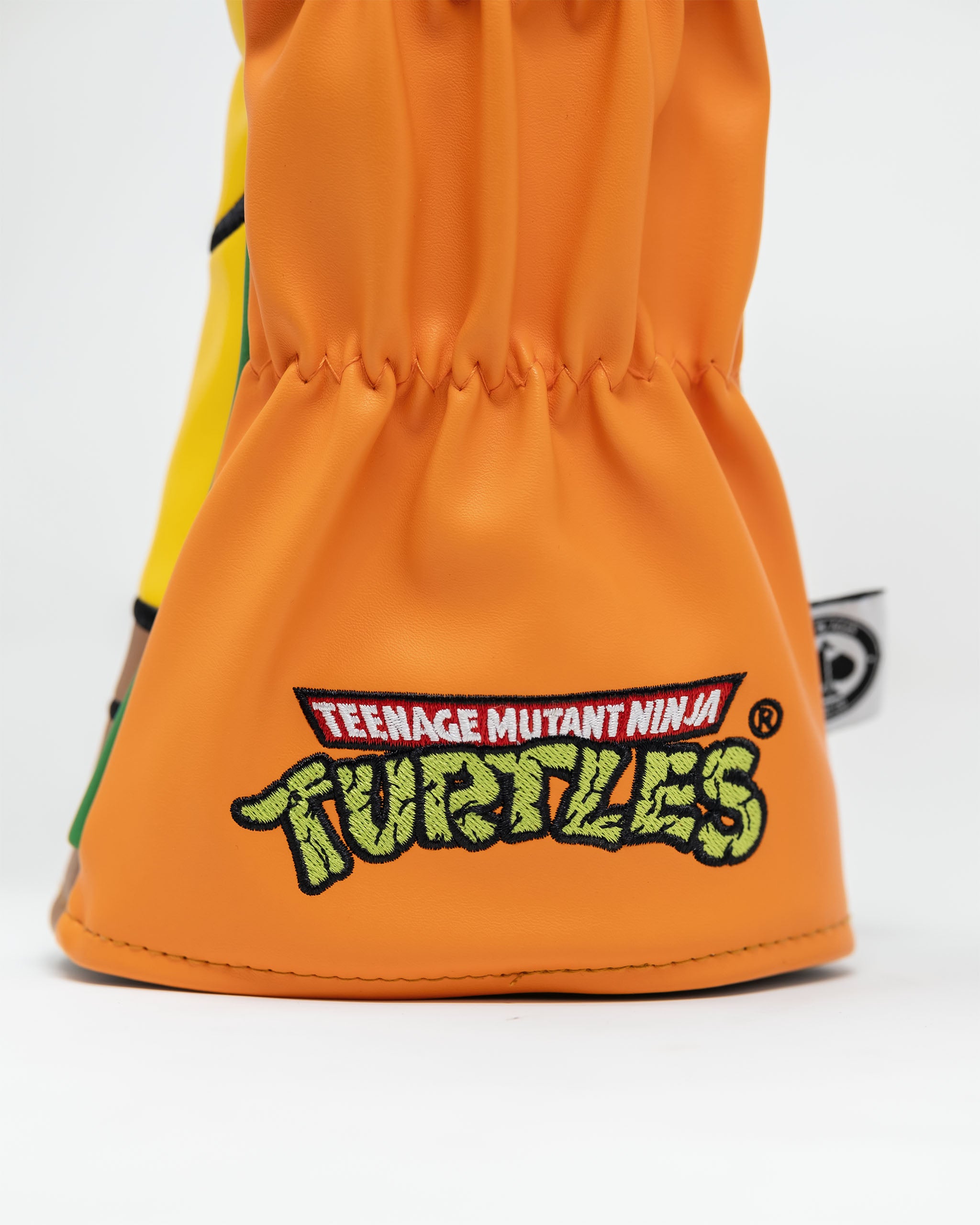 TMNT Michelangelo driver cover featuring a vibrant orange color and playful design, showcasing the character's face with a signature bandana and expressive eyes.