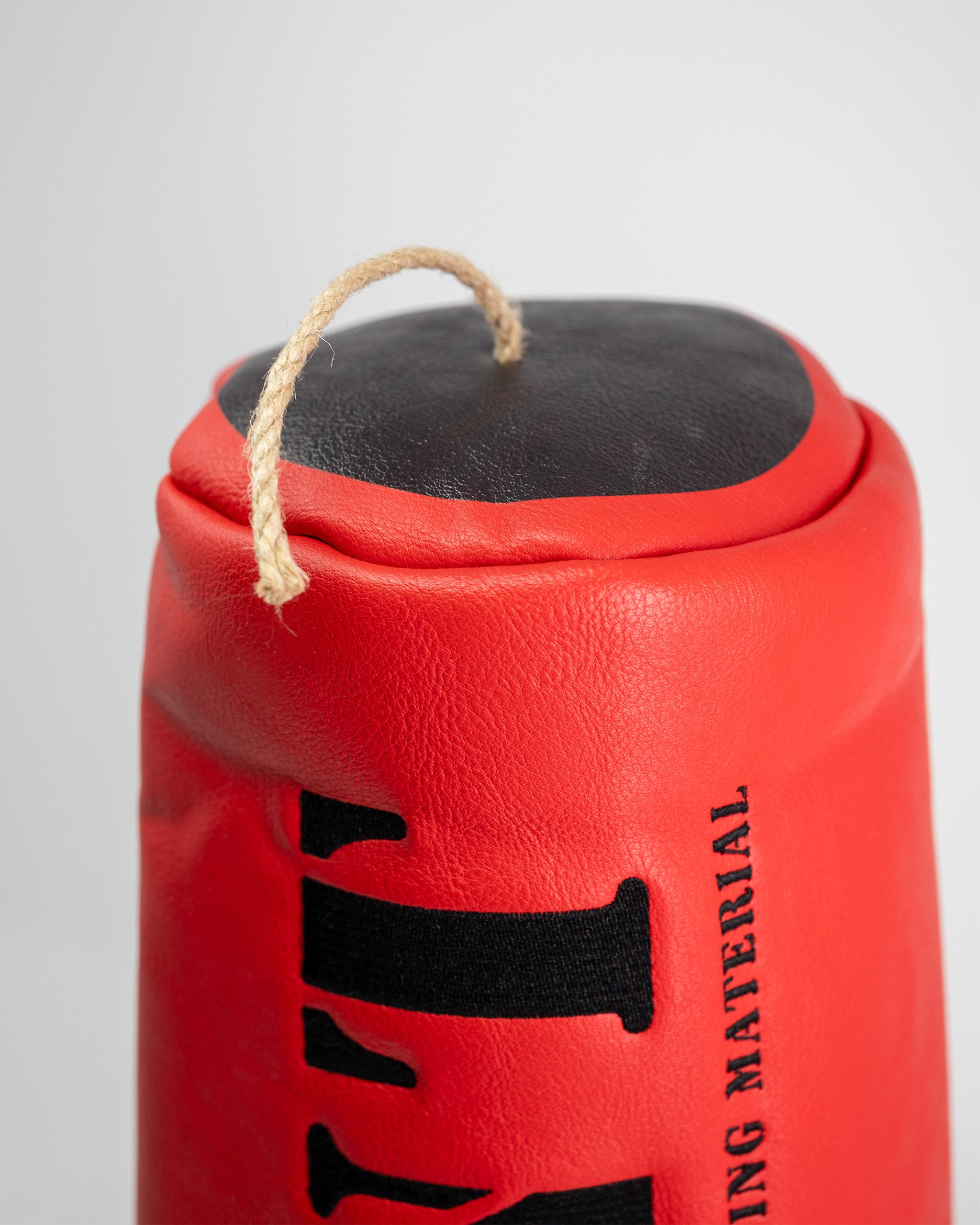 Close-up of a red TNT driver cover with a black top, featuring a beige rope handle and black printed branding.
