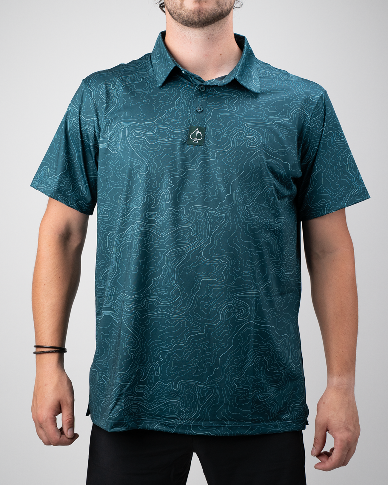 Men's Terrain golf polo in teal featuring a topographic pattern, designed for comfort and style on the course.
