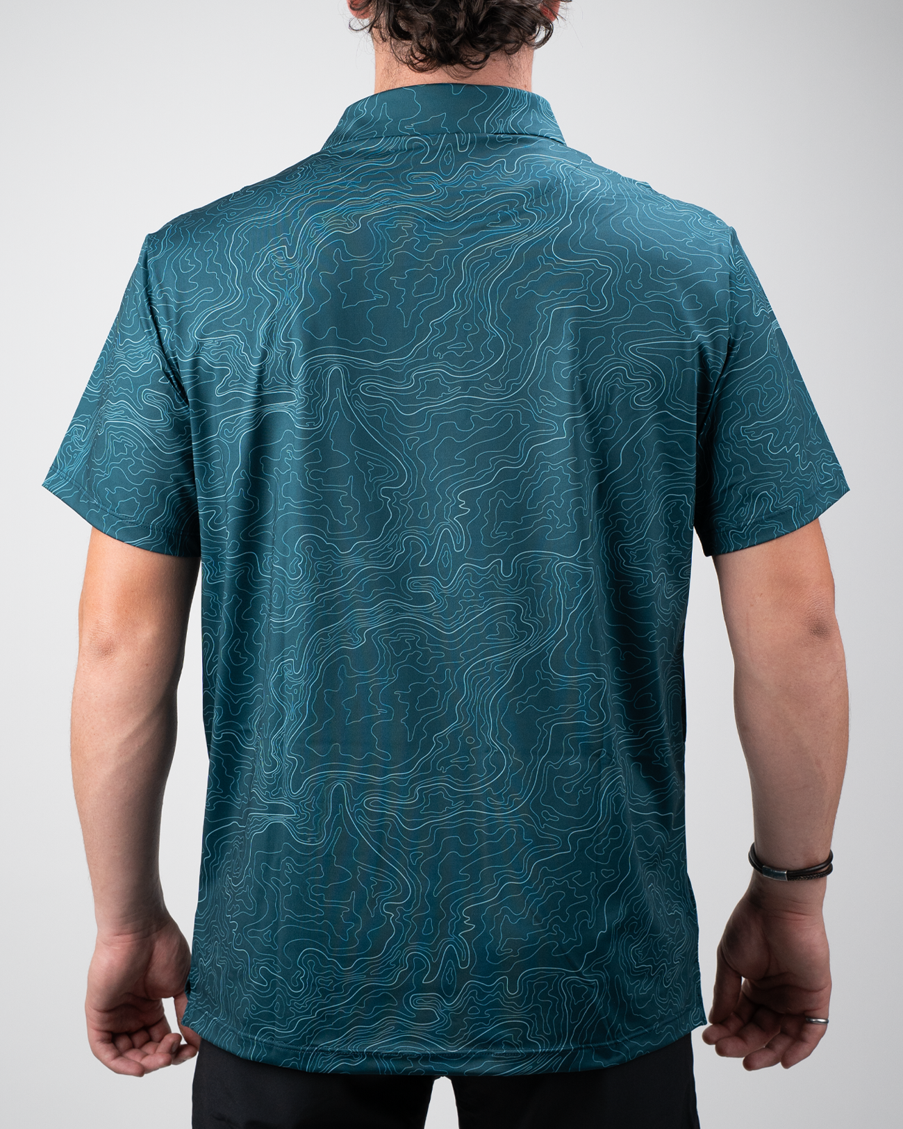 Men's Terrain golf shirt featuring a unique topographic pattern in teal, designed for style and comfort on the course.