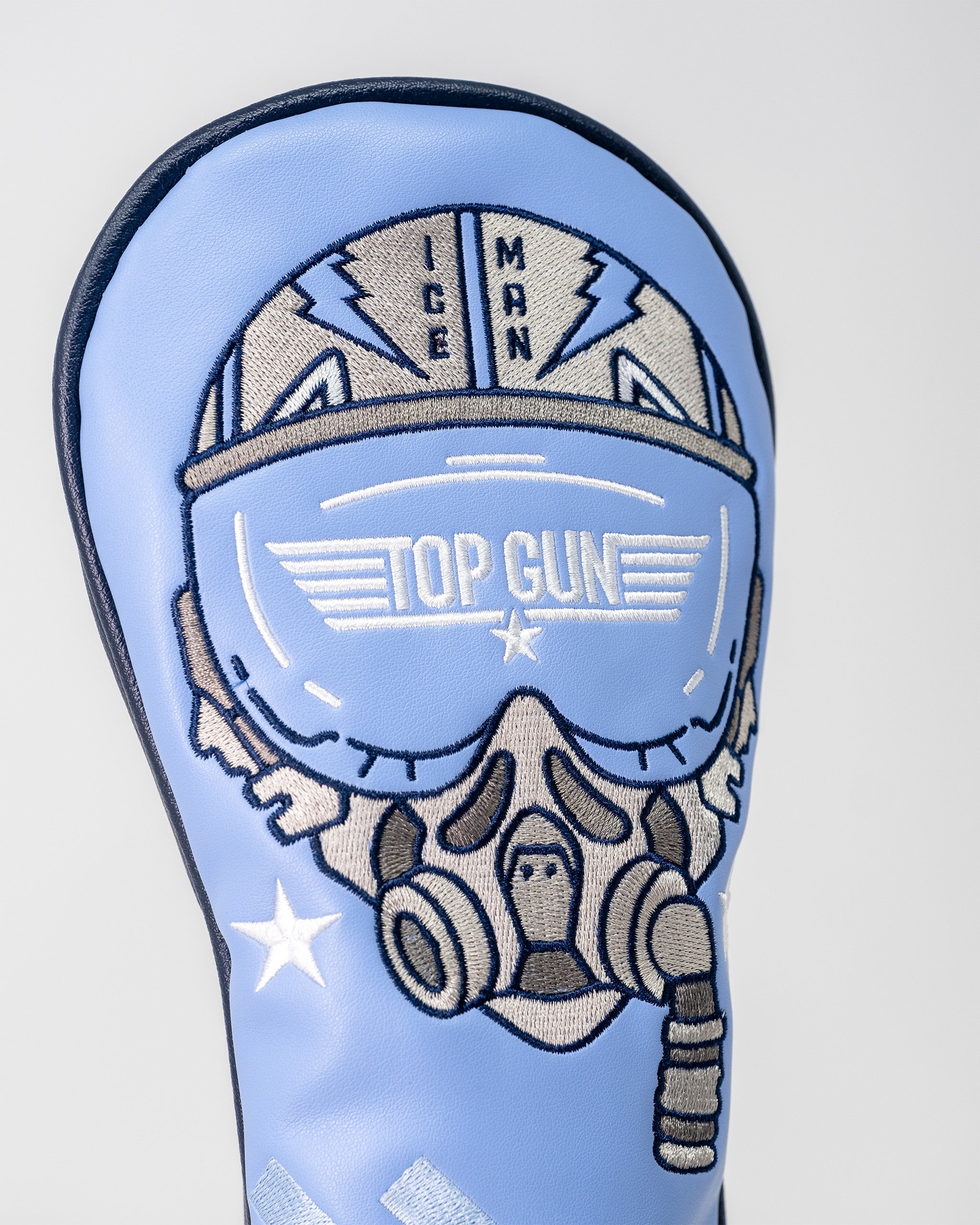 Embroidered Top Gun Ice Man helmet with goggles and stars on a light blue golf club headcover.