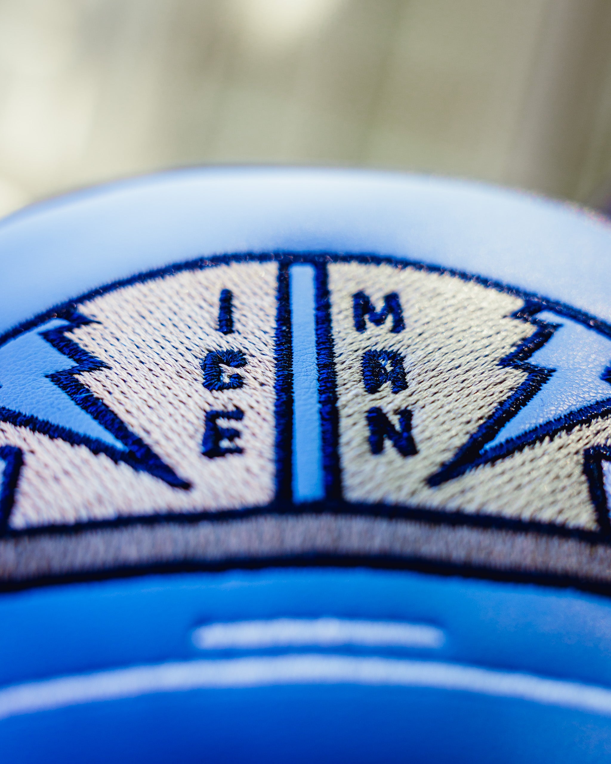 Close-up of the Top Gun Ice Man fairway headcover showing embroidered navy blue and beige patch with compass design and "Ice Man" text.