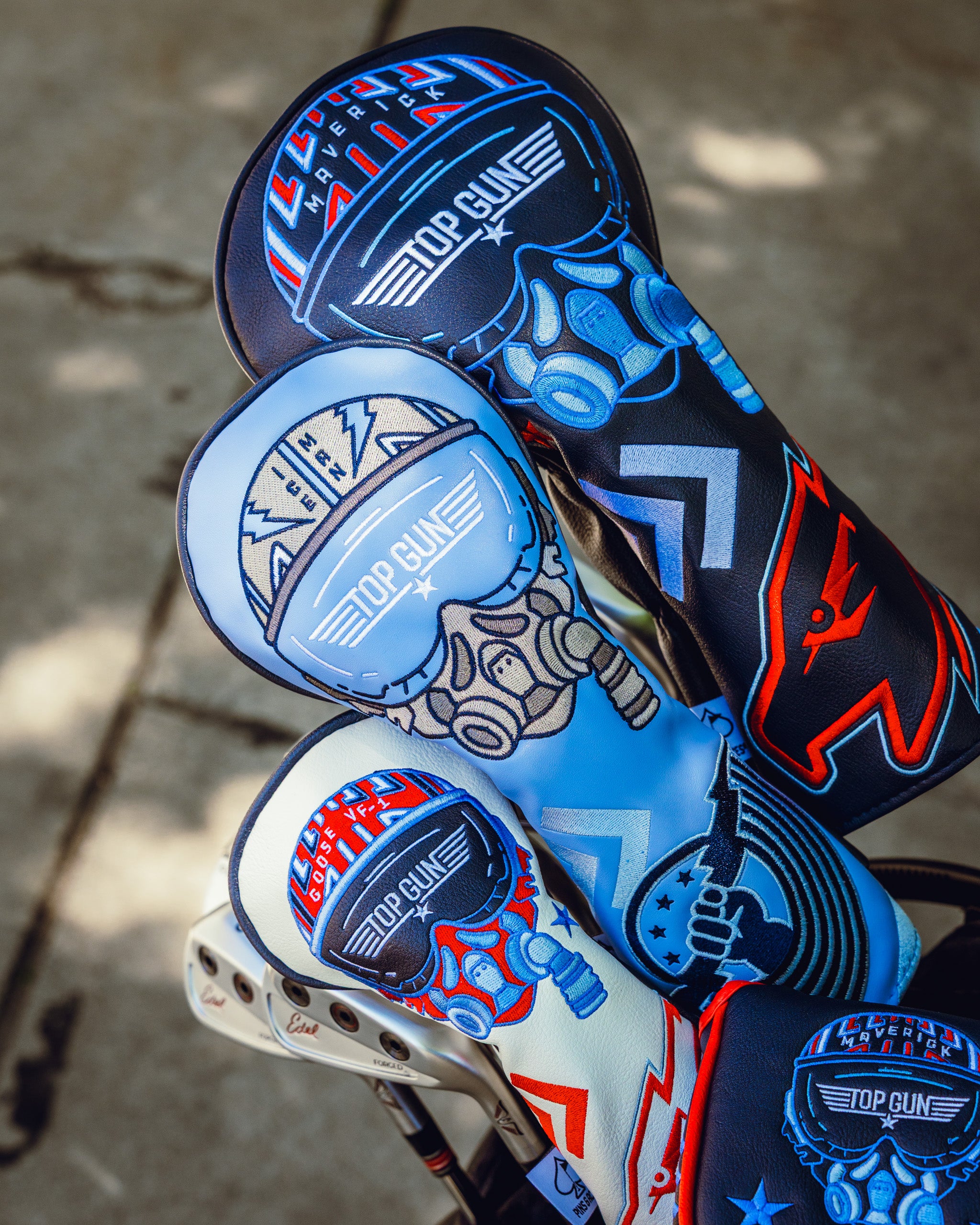 Three Top Gun Maverick-themed golf driver headcovers featuring aviation and fighter pilot designs in black, white, and blue colors.