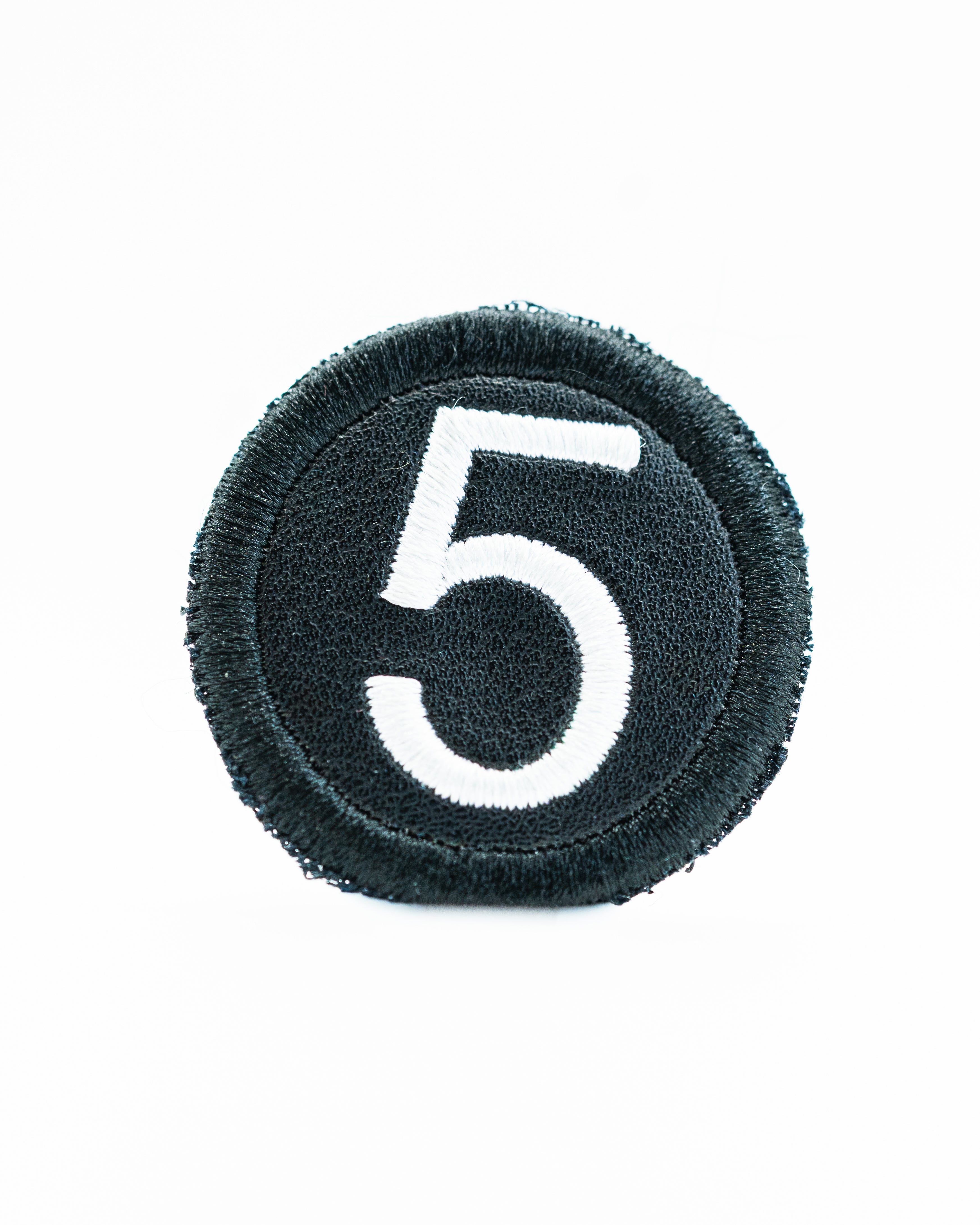 Black headcover patch featuring a white embroidered number five, designed for golf enthusiasts.