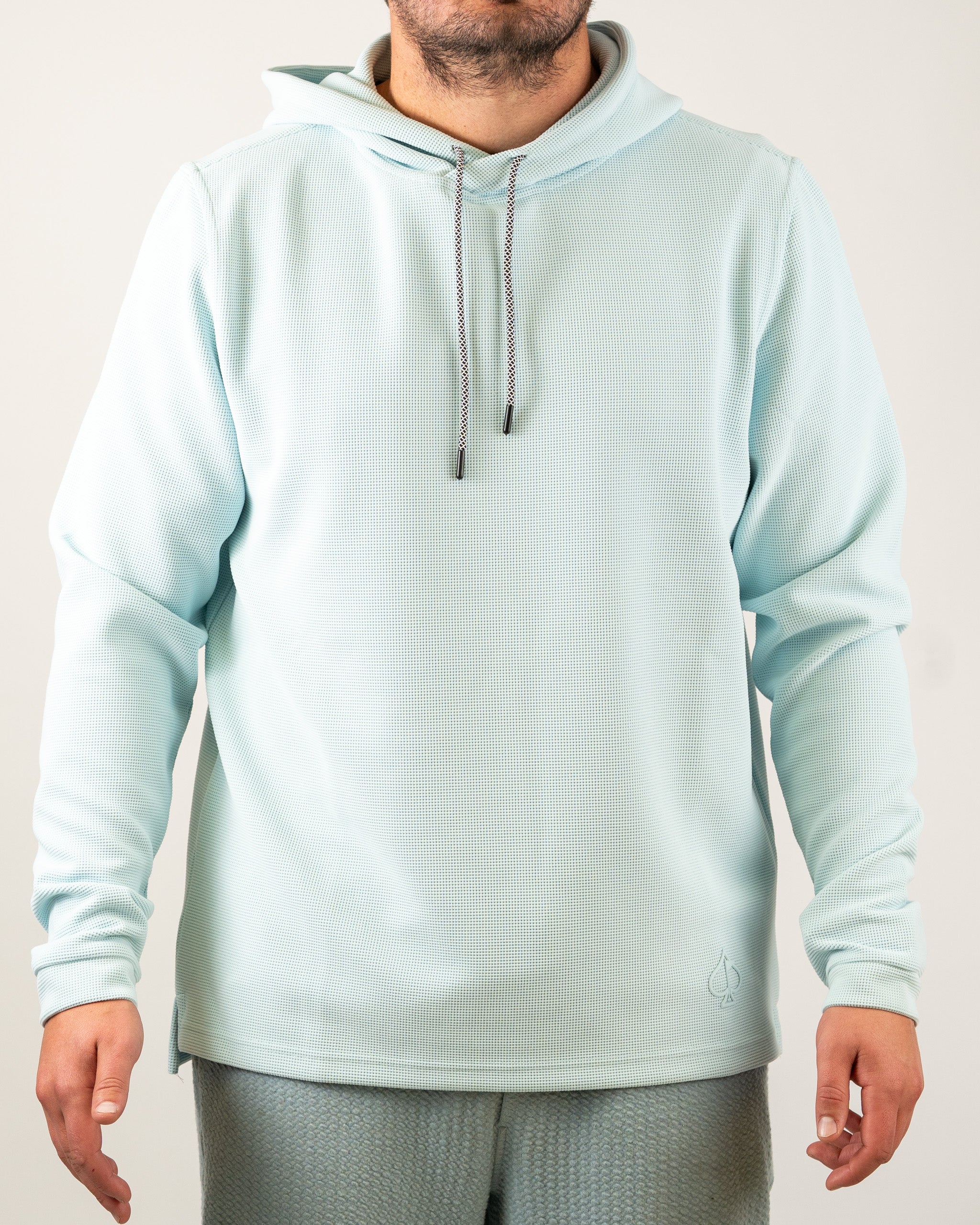 Ice blue waffle grid hoodie featuring a relaxed fit, adjustable drawstring hood, and subtle logo detail, perfect for golfers.