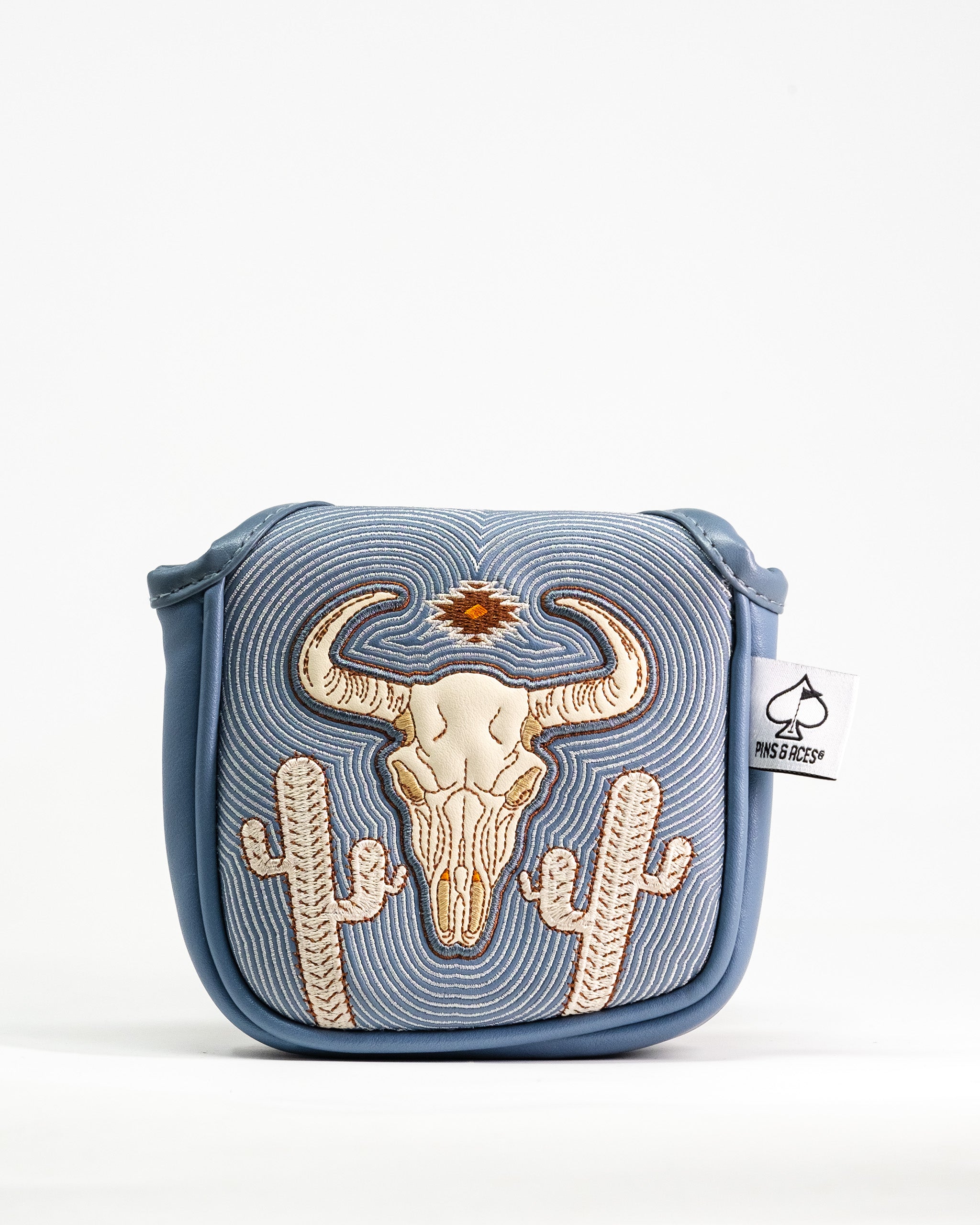 Embroidered western-style skull and cactus design on a blue golf mallet putter cover with a Pins & Aces tag.