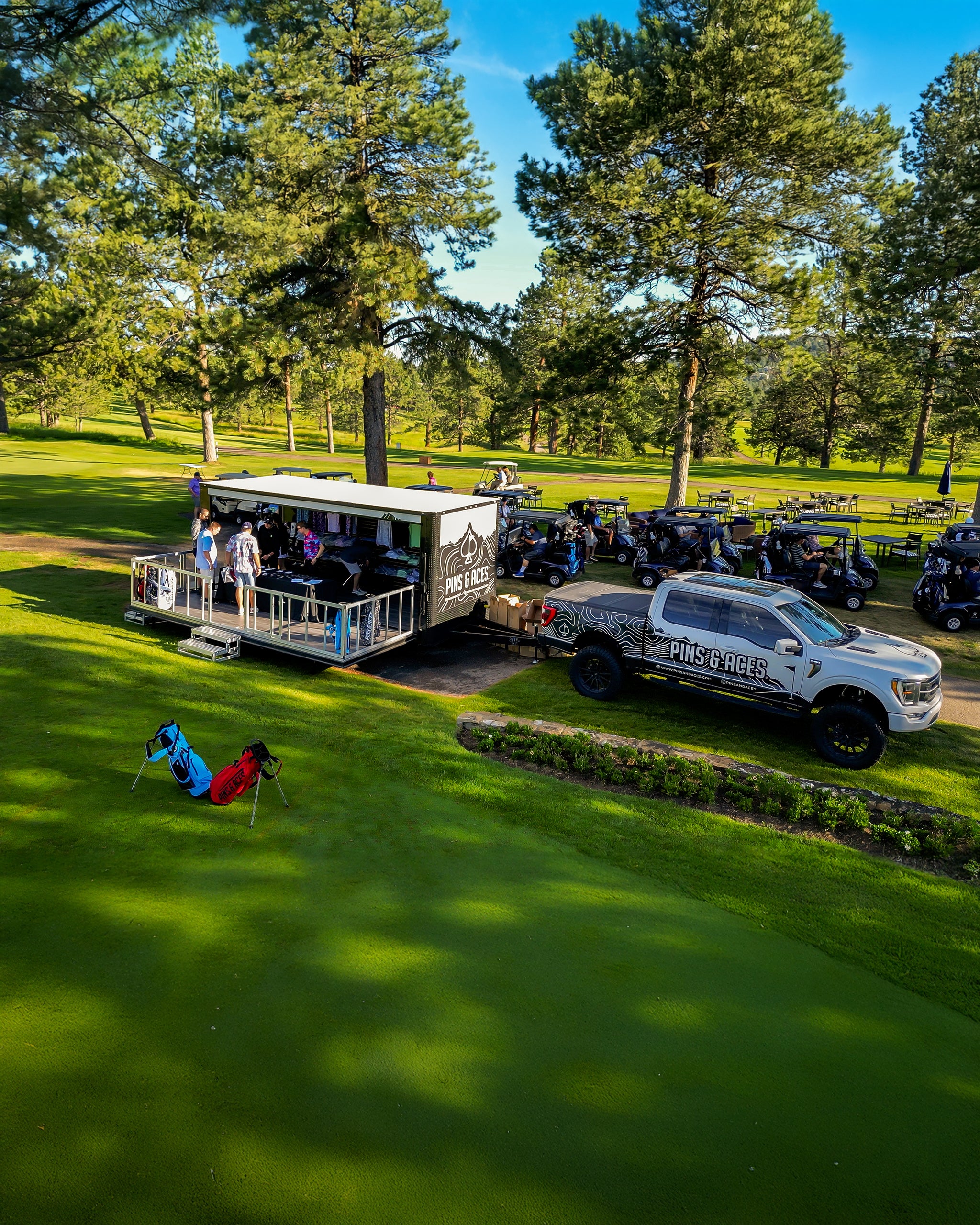 Golf course scene with a branded truck, golf carts, and people; focus on bold, unique golf apparel and accessories.