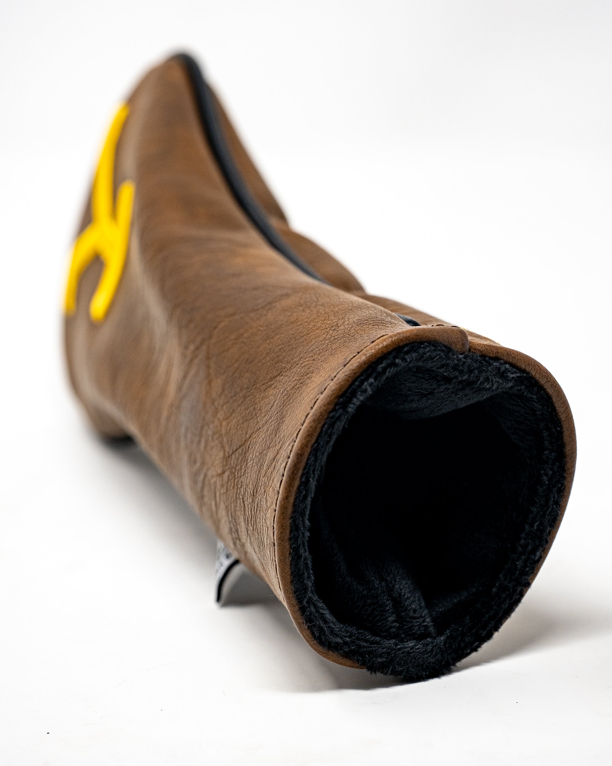 Brown leather golf club headcover with yellow logo and black interior, designed for bold, unique golf style.