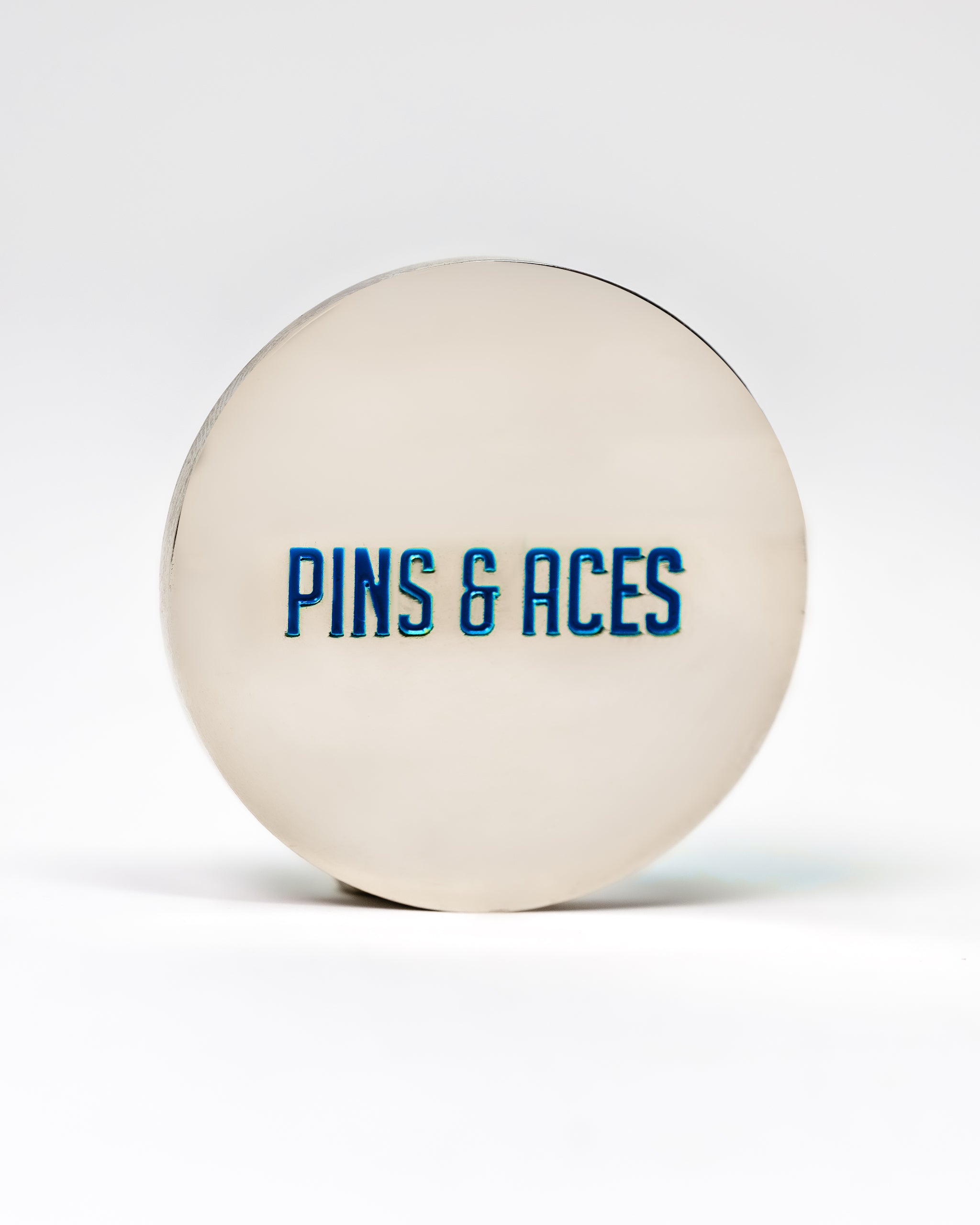 Cool Mint ball marker featuring "PINS & ACES" in bold blue lettering on a sleek silver surface.