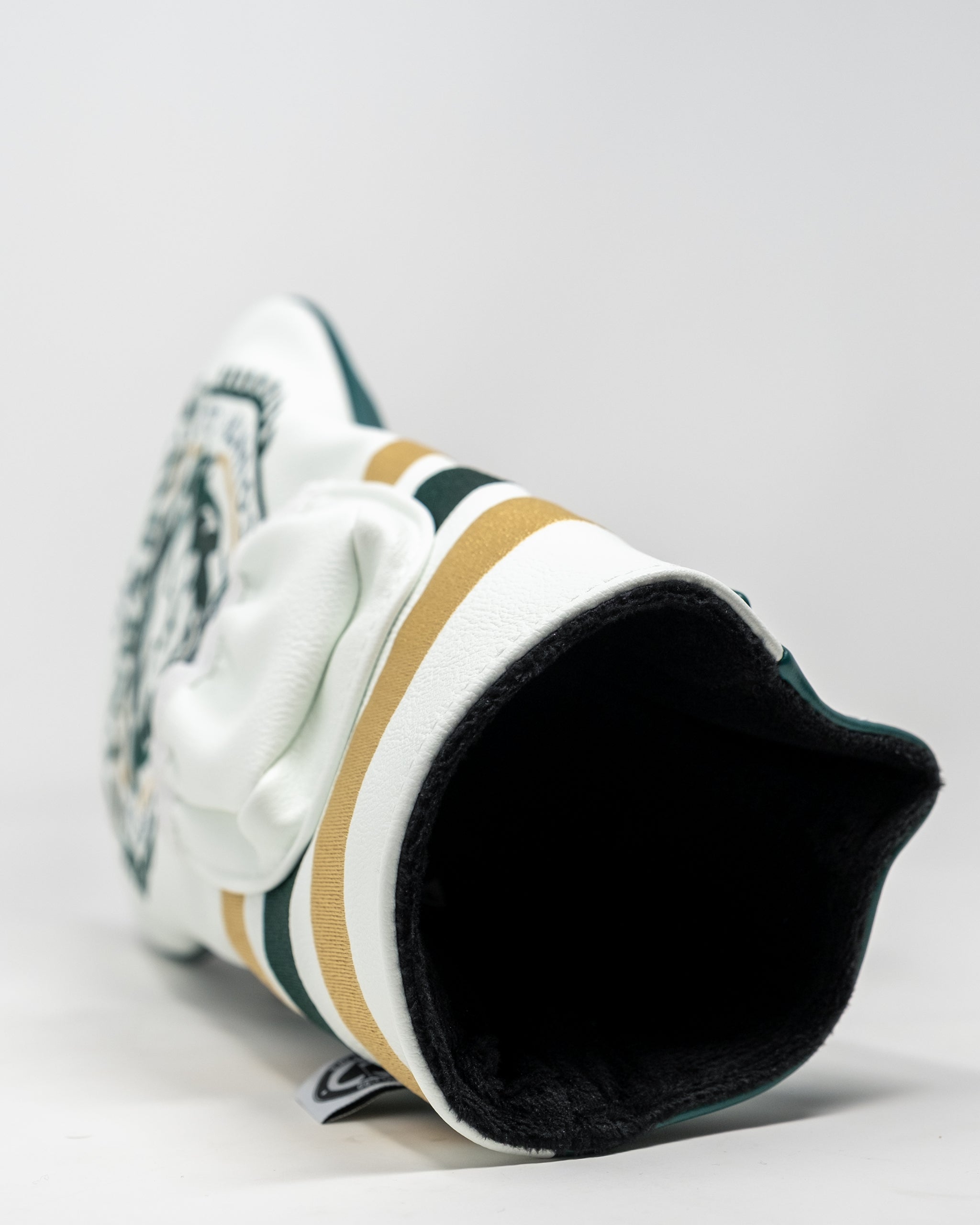 Bold white golf headcover with black, gold, and green stripes, featuring a graphic logo for standout style on the course.