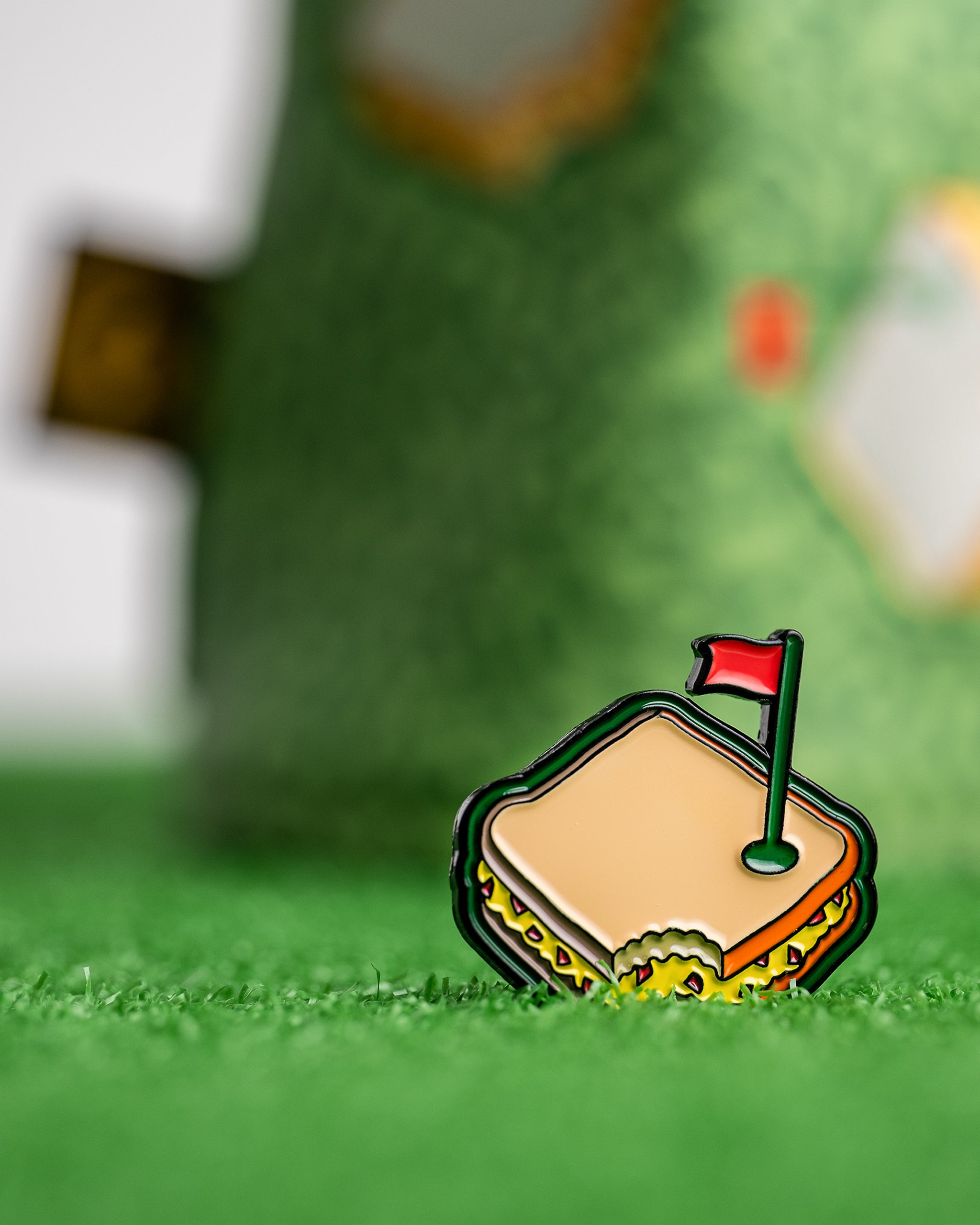 Pimento cheese sandwich ball marker in a golf setting on green turf.