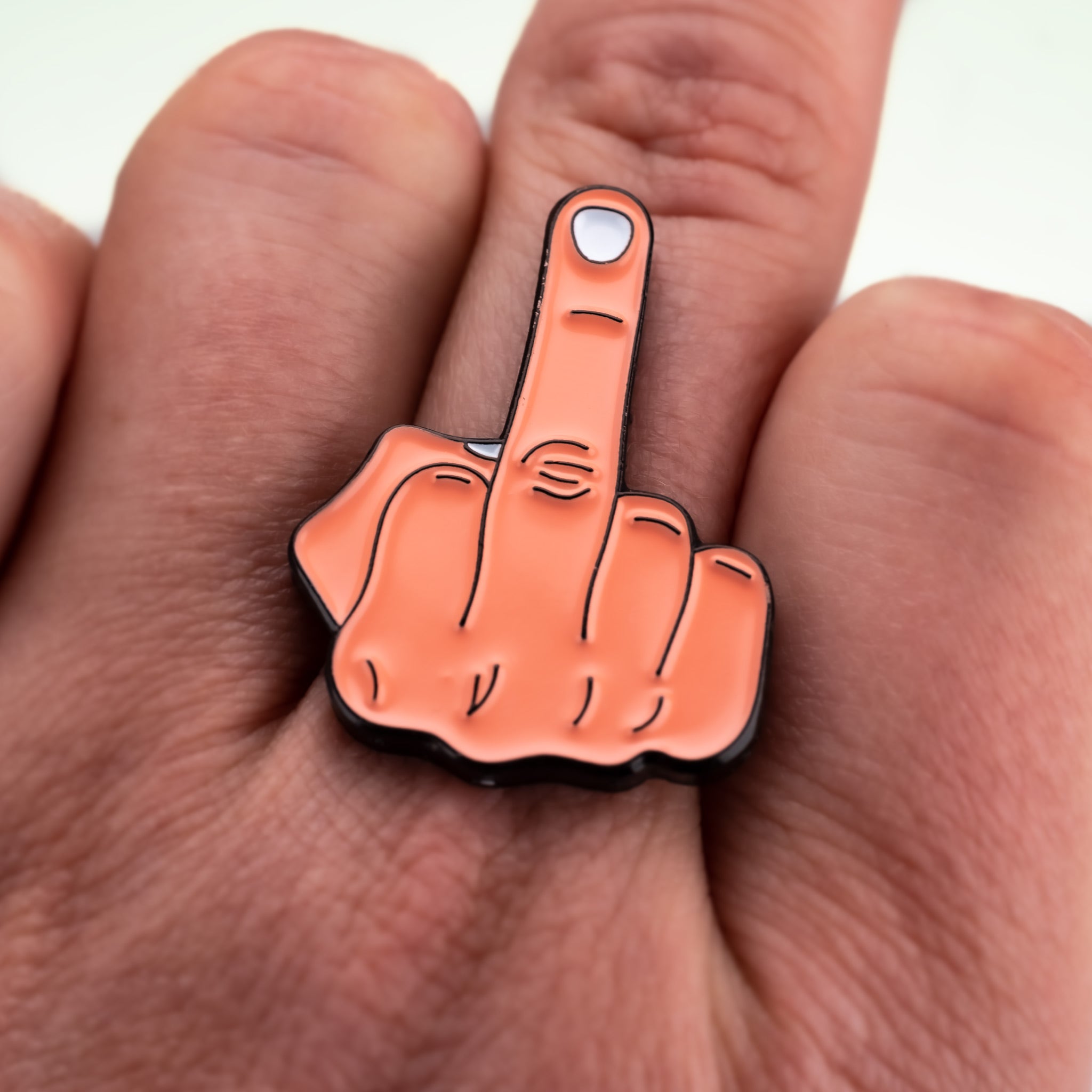 Middle Finger Ball Marker held in hand, featuring a playful design that humorously expresses frustration, ideal for golf enthusiasts.