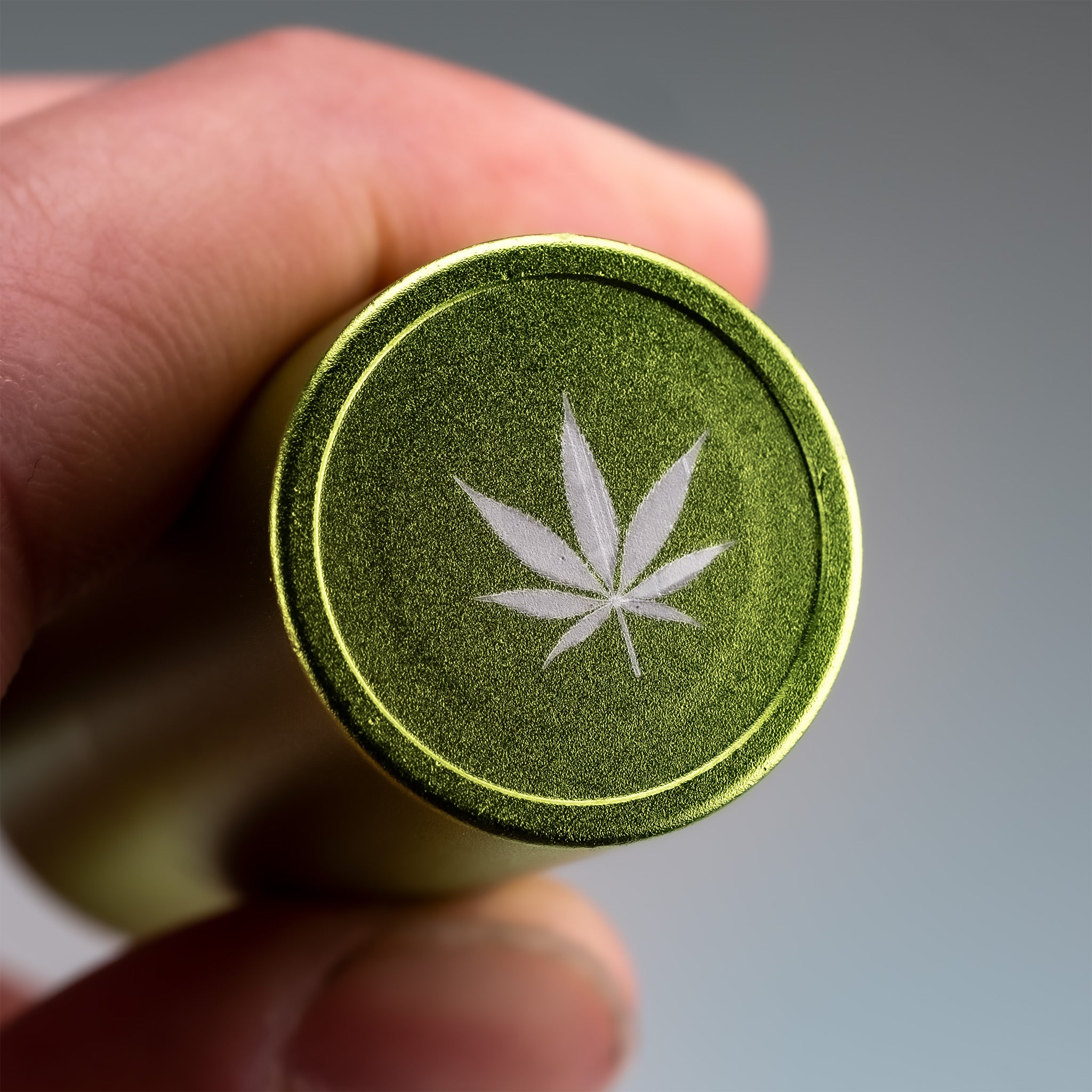 Pot Leaf Ball Stamp held in a closed hand, featuring a detailed leaf design perfect for crafts or baking.