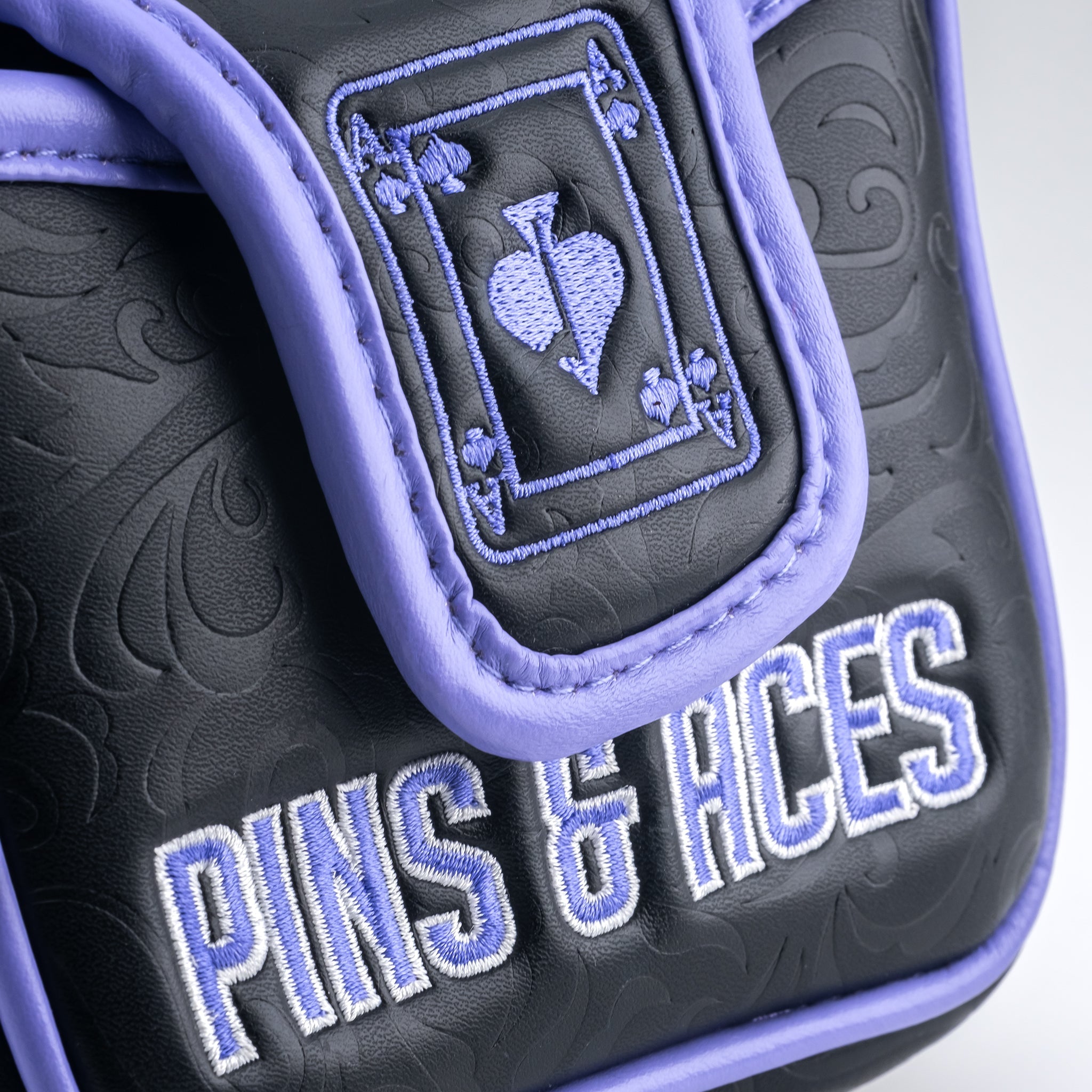 Black mallet putter cover featuring an Ace of Spades design and vibrant purple accents, branded with Pins & Aces.