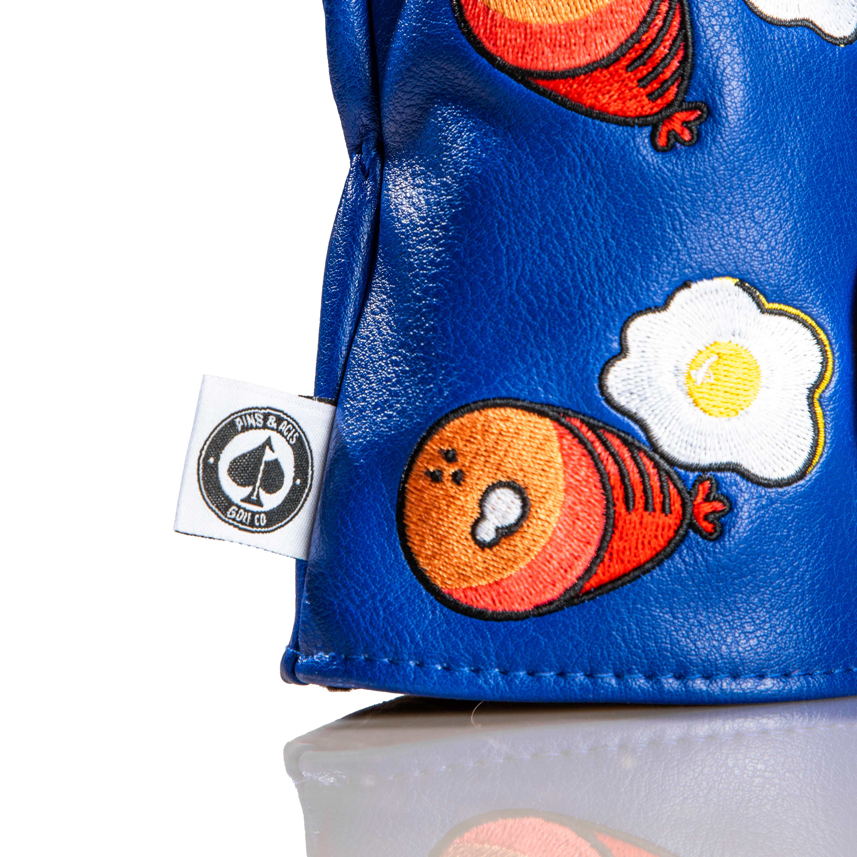 Bold blue driver cover featuring playful ham and egg graphics, perfect for golfers wanting to add fun to their game.