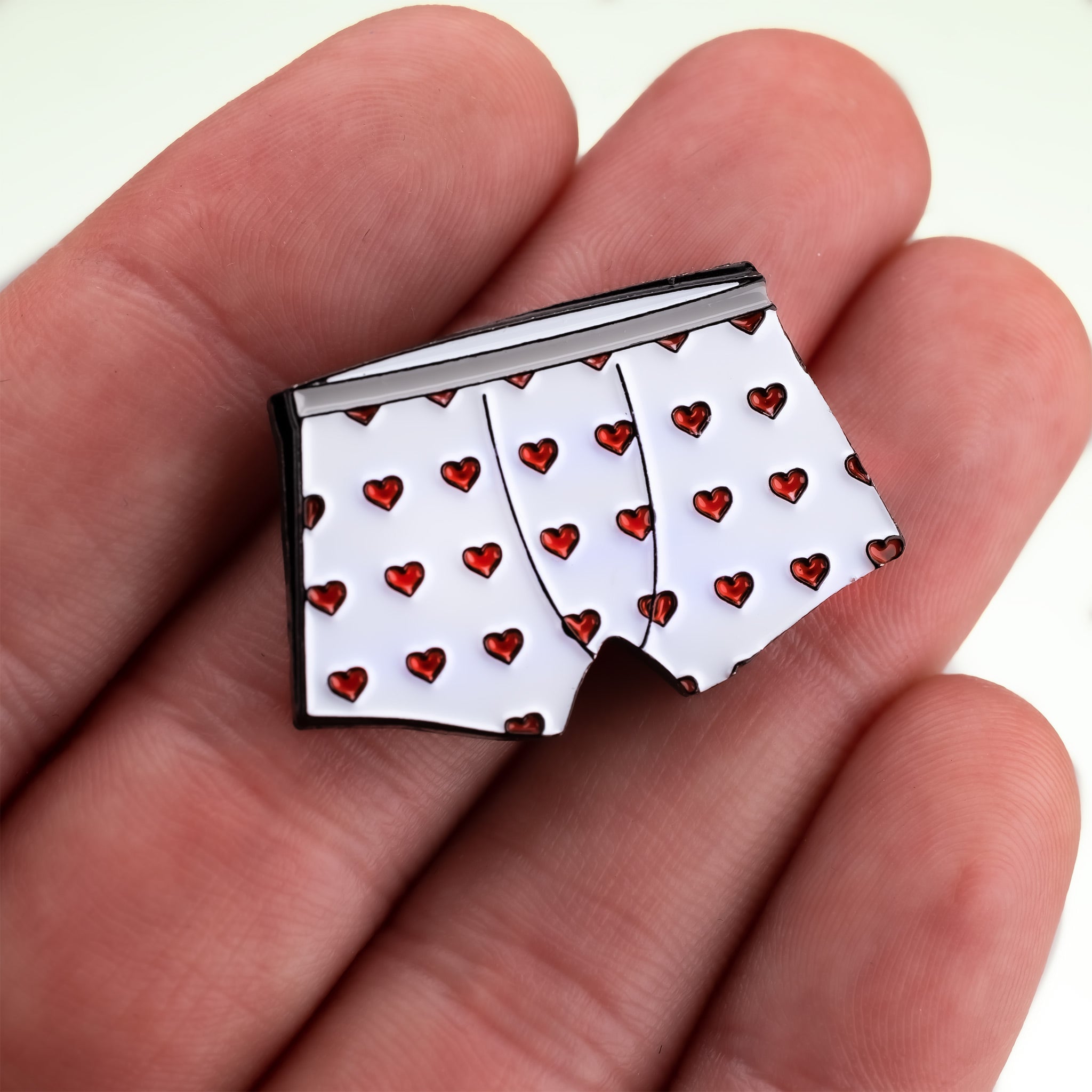 Heart Boxers Ball Marker featuring a playful design of white boxers adorned with red hearts, perfect for adding flair to your golf game.