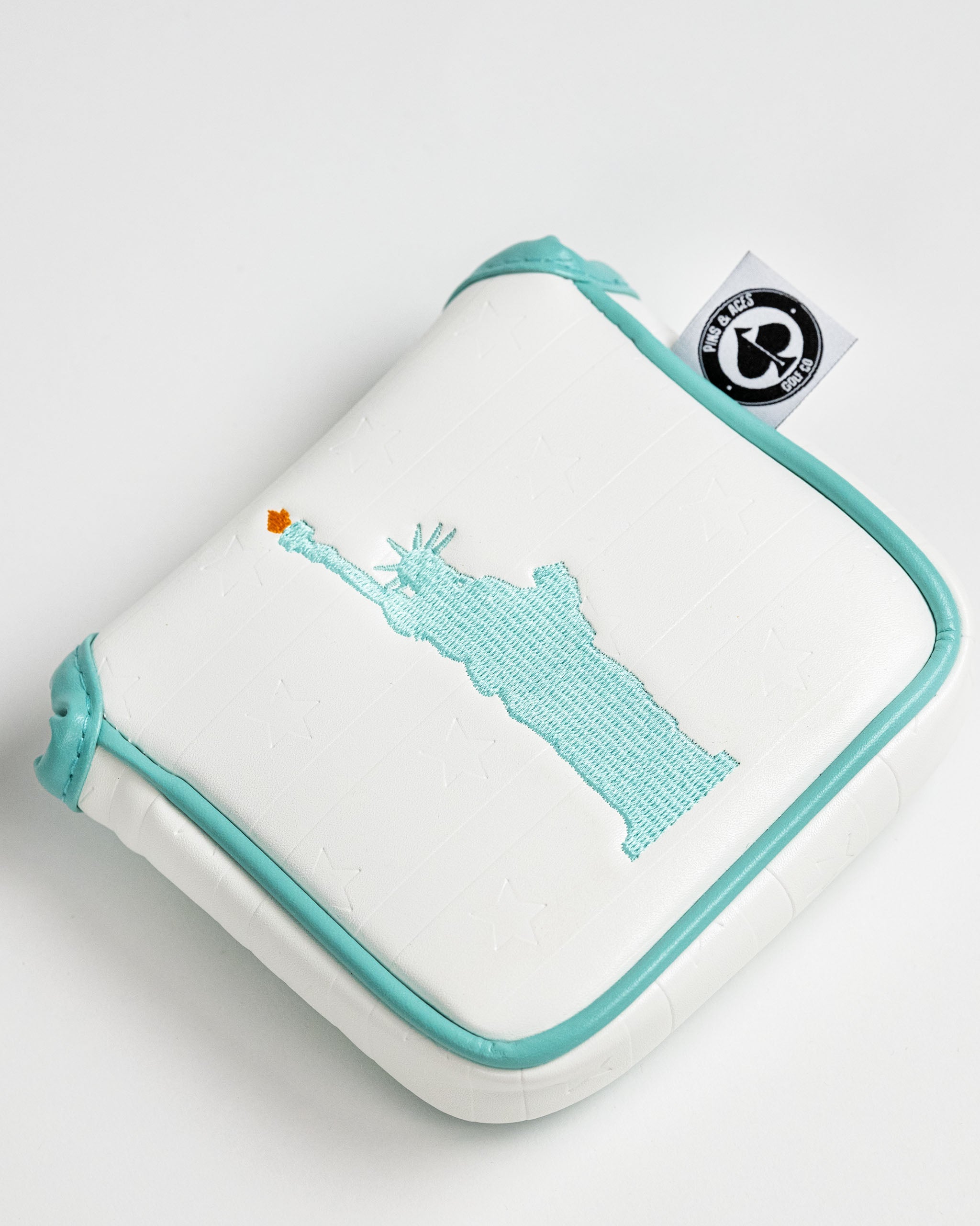 Liberty mallet cover featuring a stitched design of the Statue of Liberty on a white background with teal accents.