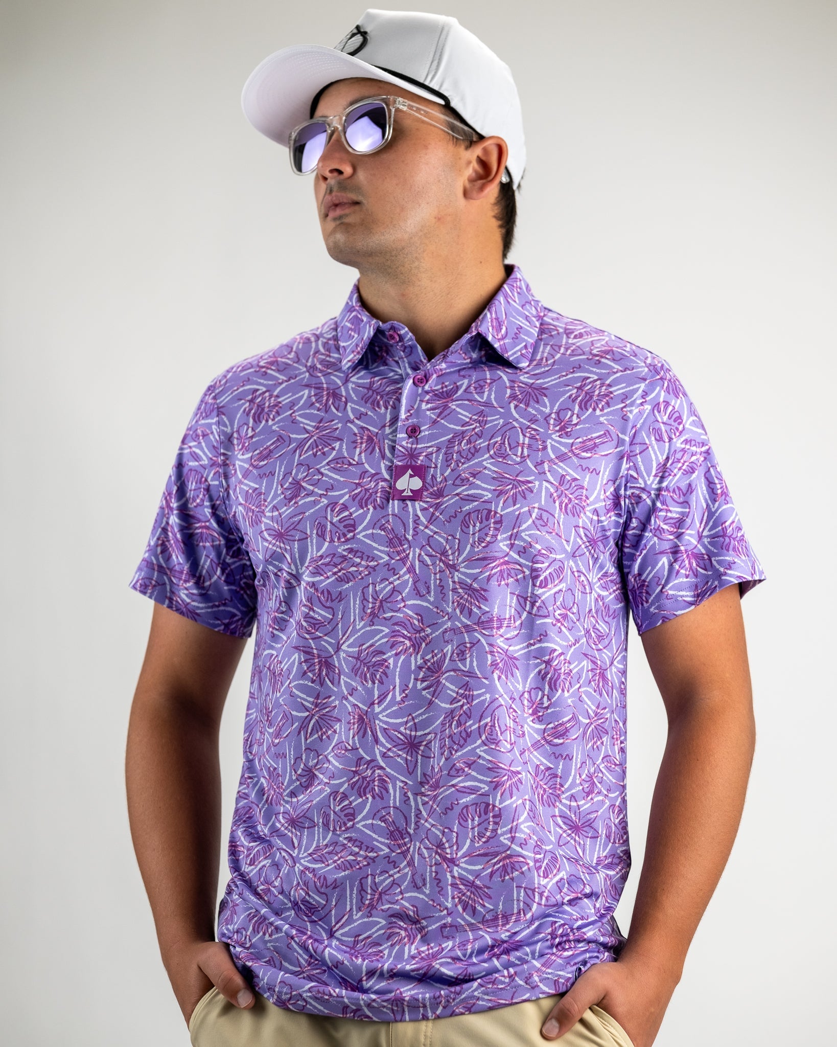 Men's Margaritaville 5 O'Clock Sunset polo shirt featuring a vibrant purple palm leaf pattern, perfect for stylish golf outings.