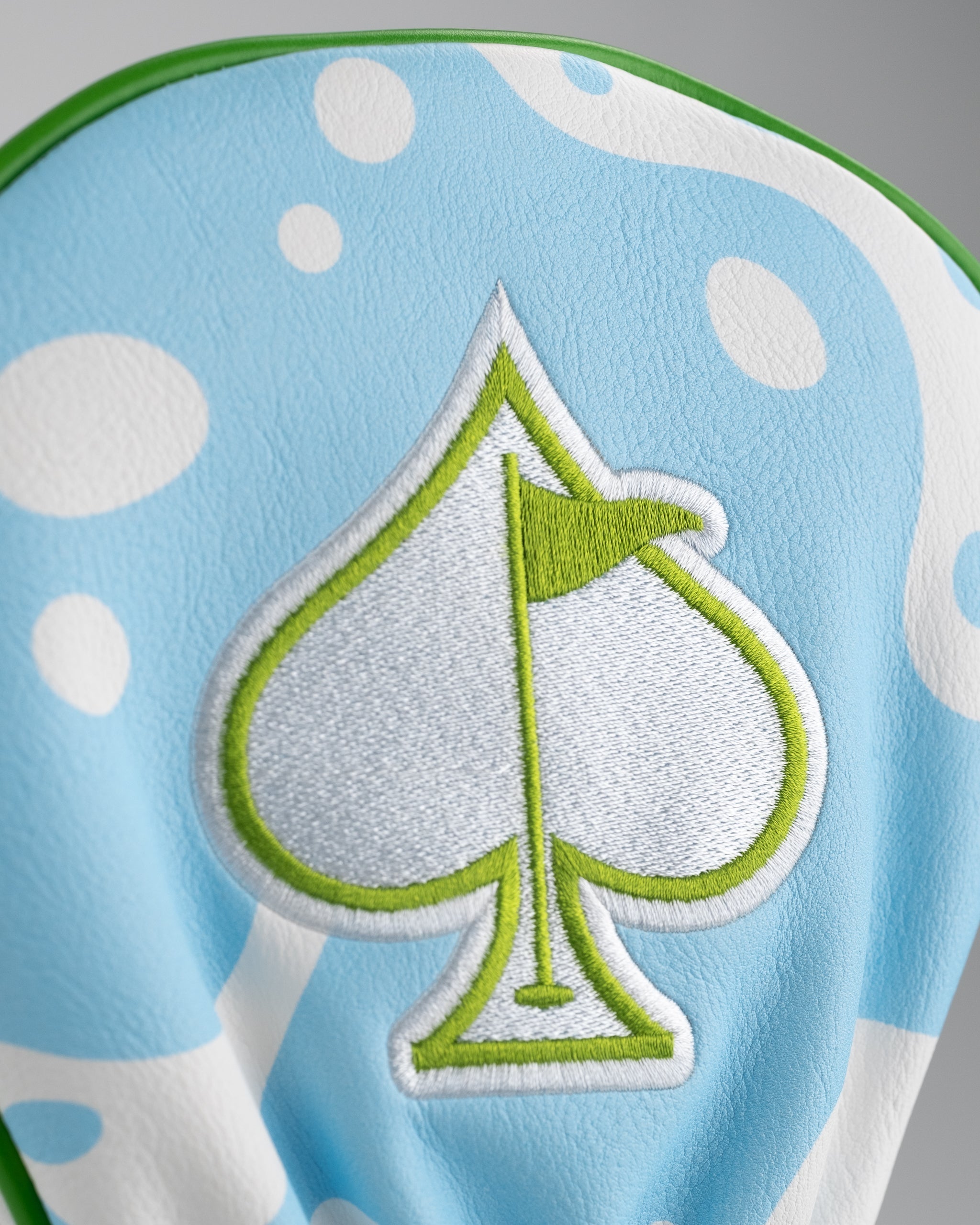 Margaritaville driver cover featuring a light blue design with a green spade emblem and playful polka dots.
