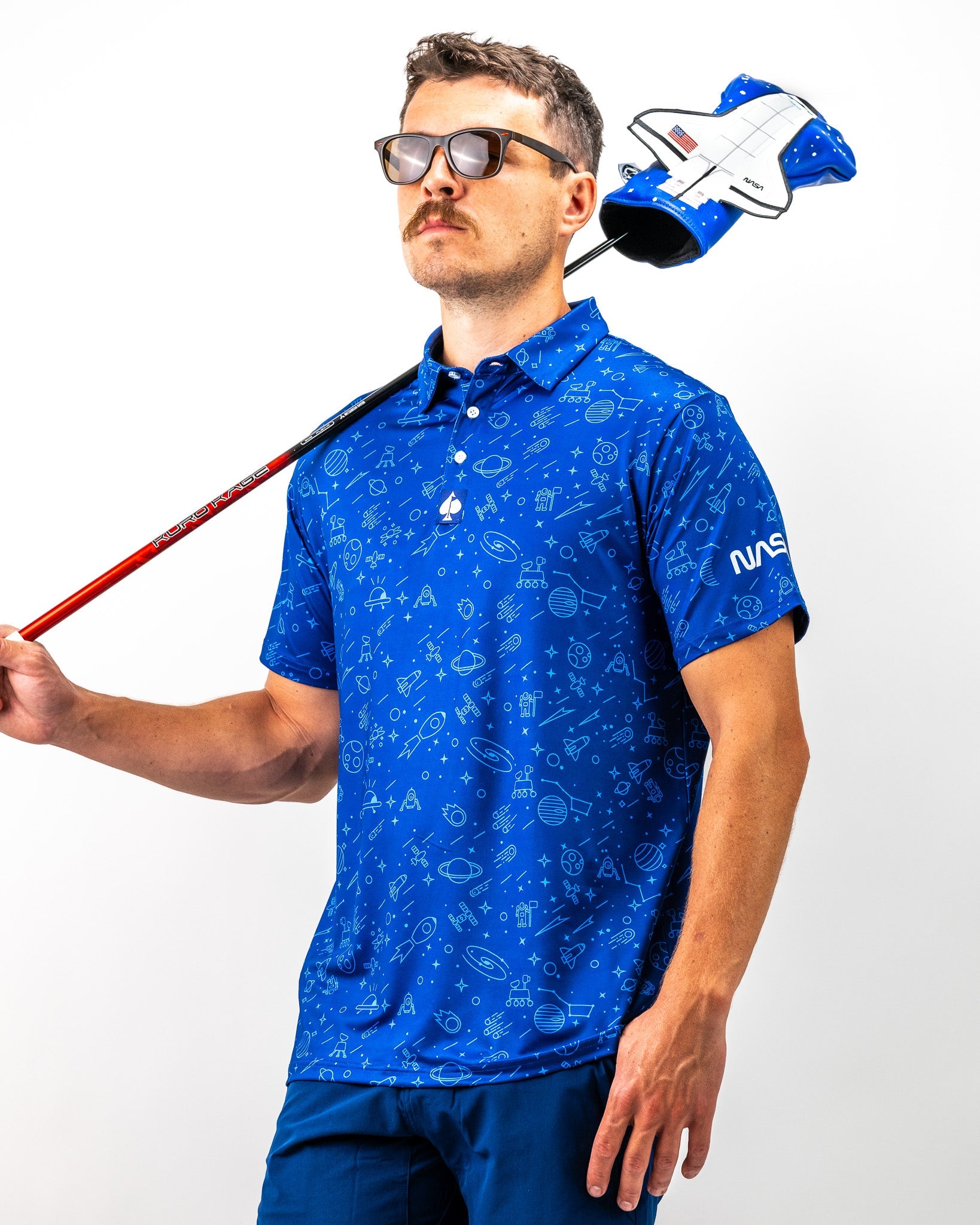 Bold blue NASA polo featuring space-themed graphics, worn by a model holding a golf club and wearing sunglasses.