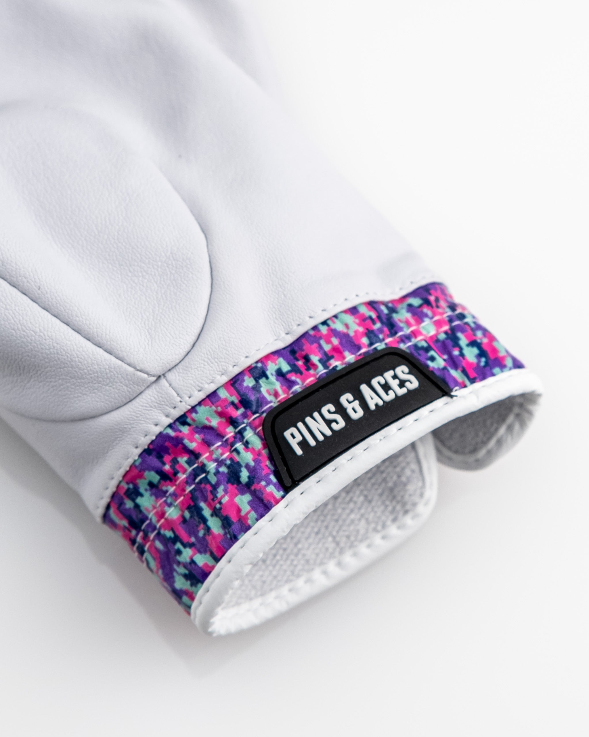 Premium Tour Glove in vivid camo featuring a colorful wristband and the Pins & Aces logo for standout style on the course.