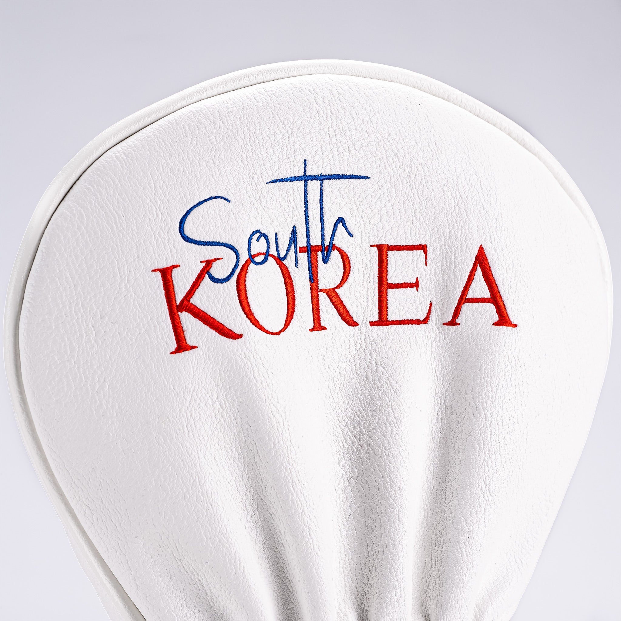 White driver cover featuring bold red and blue embroidery of "South Korea" for stylish golf protection.