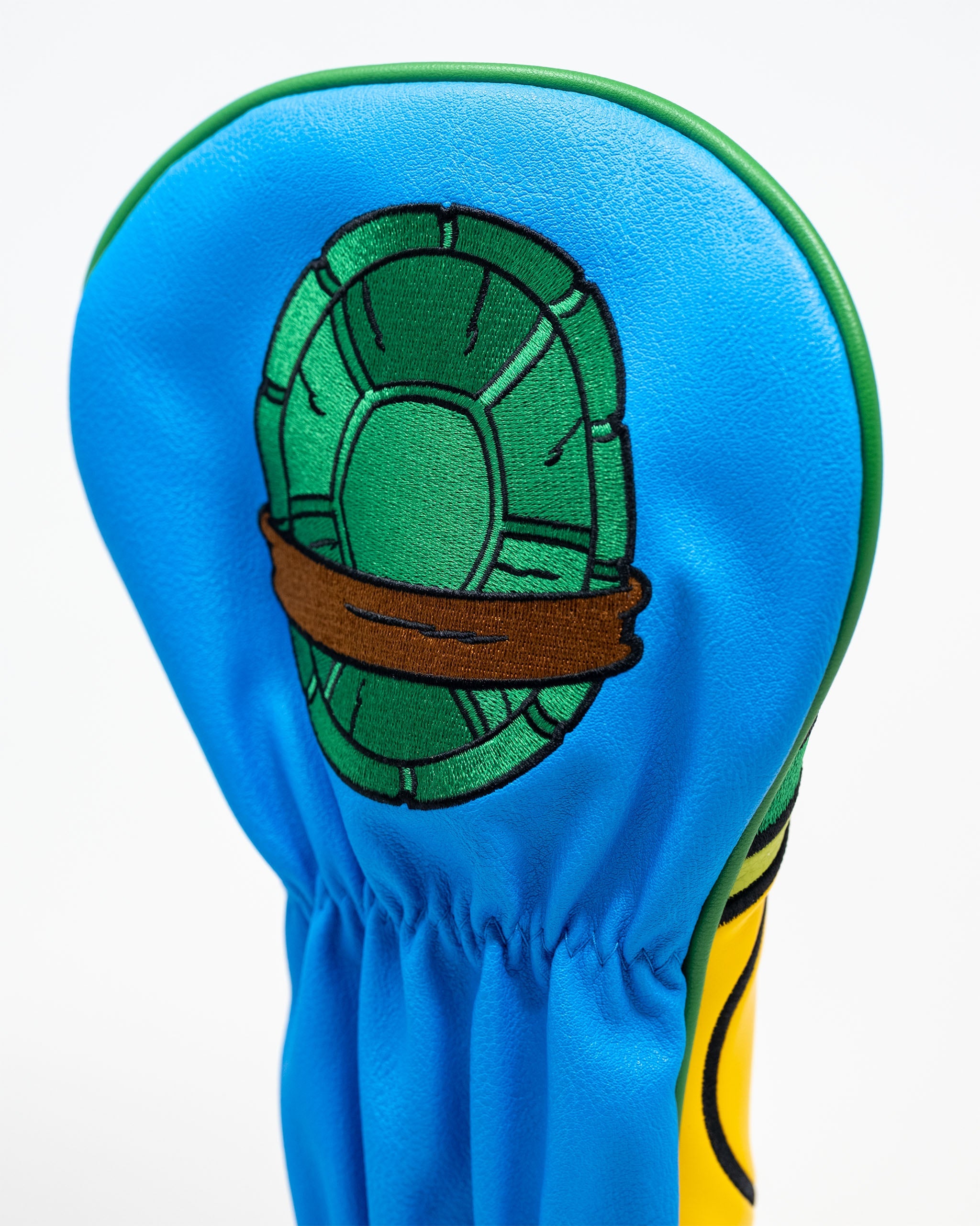 Leonardo-themed golf driver cover featuring a blue design with a turtle shell graphic and a brown band.
