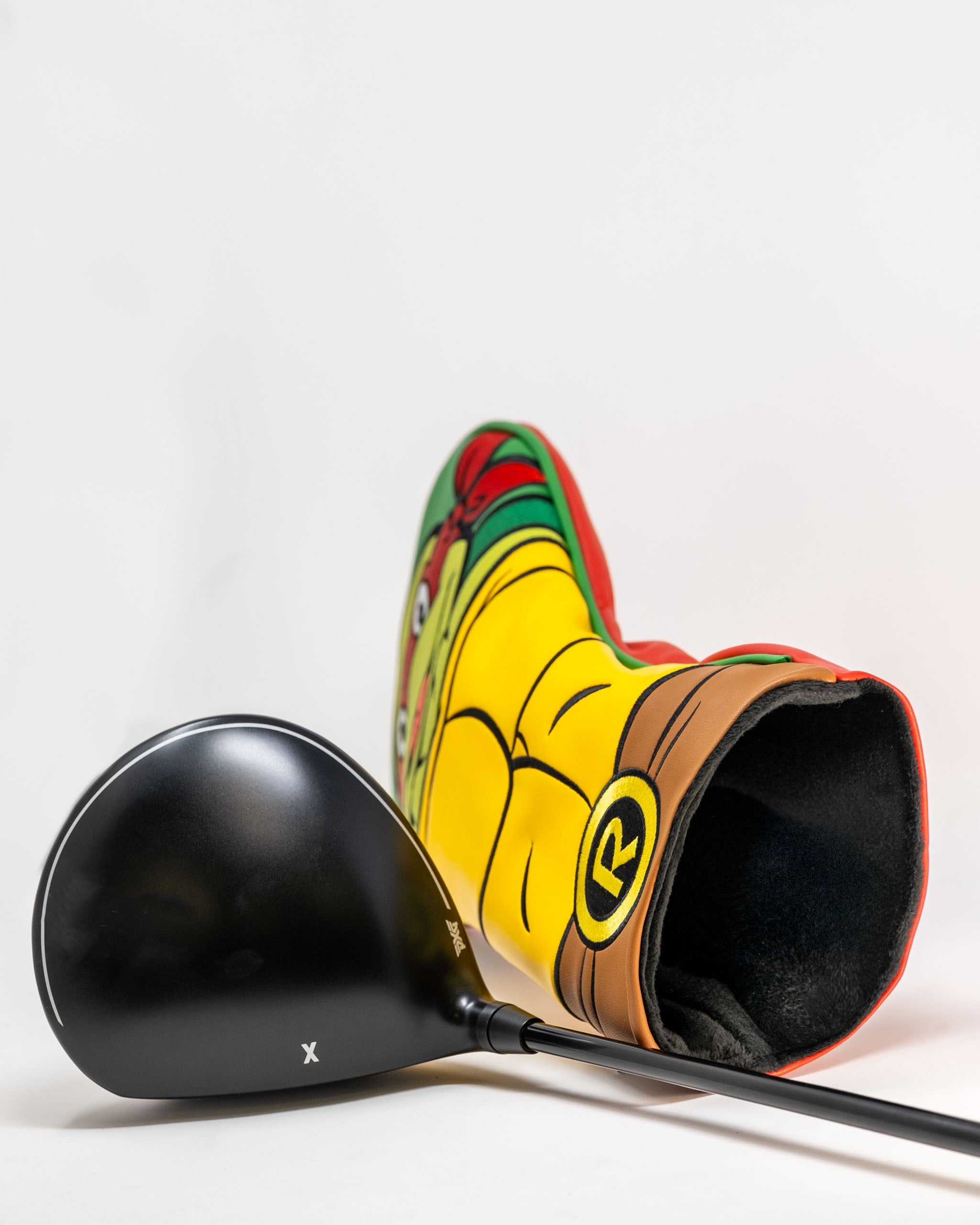 TMNT Raphael driver cover featuring vibrant colors and character design, placed next to a black golf driver club.