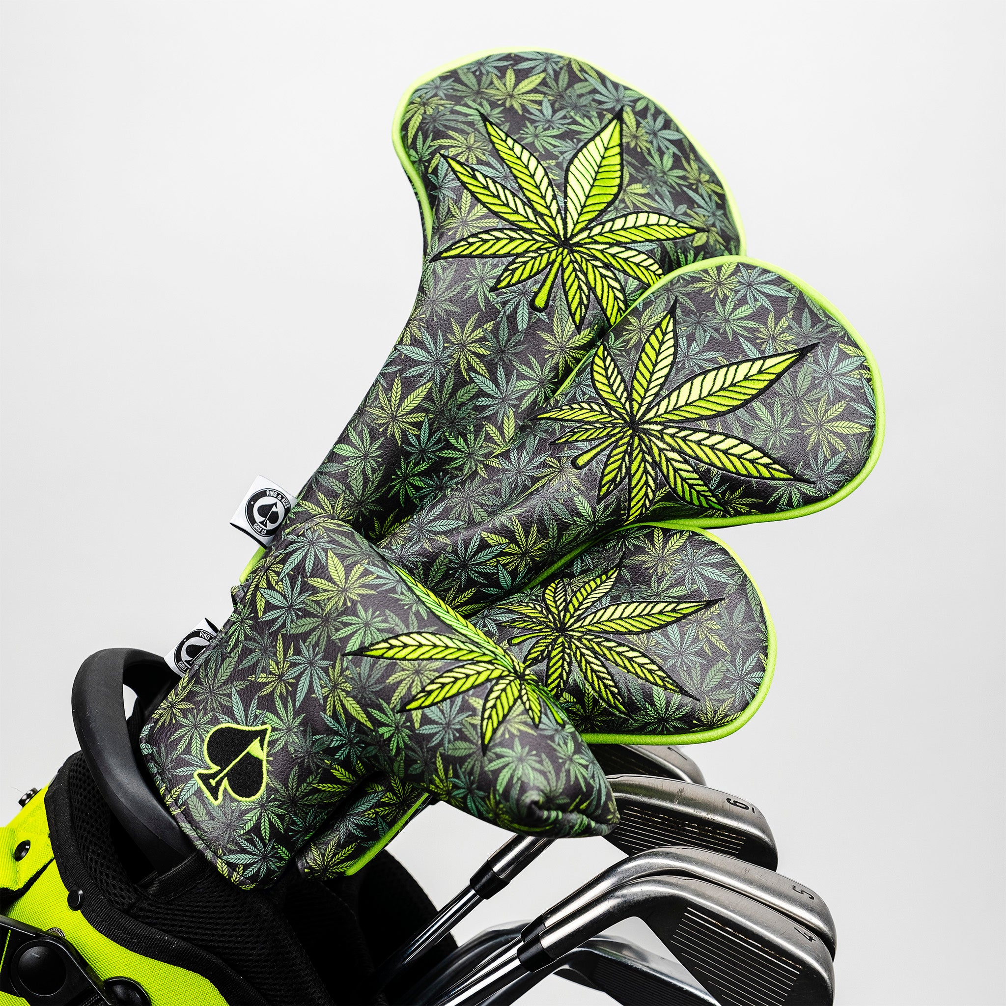 Golf headcovers with bold cannabis leaf pattern in neon green and black, perfect for standout golf accessories.