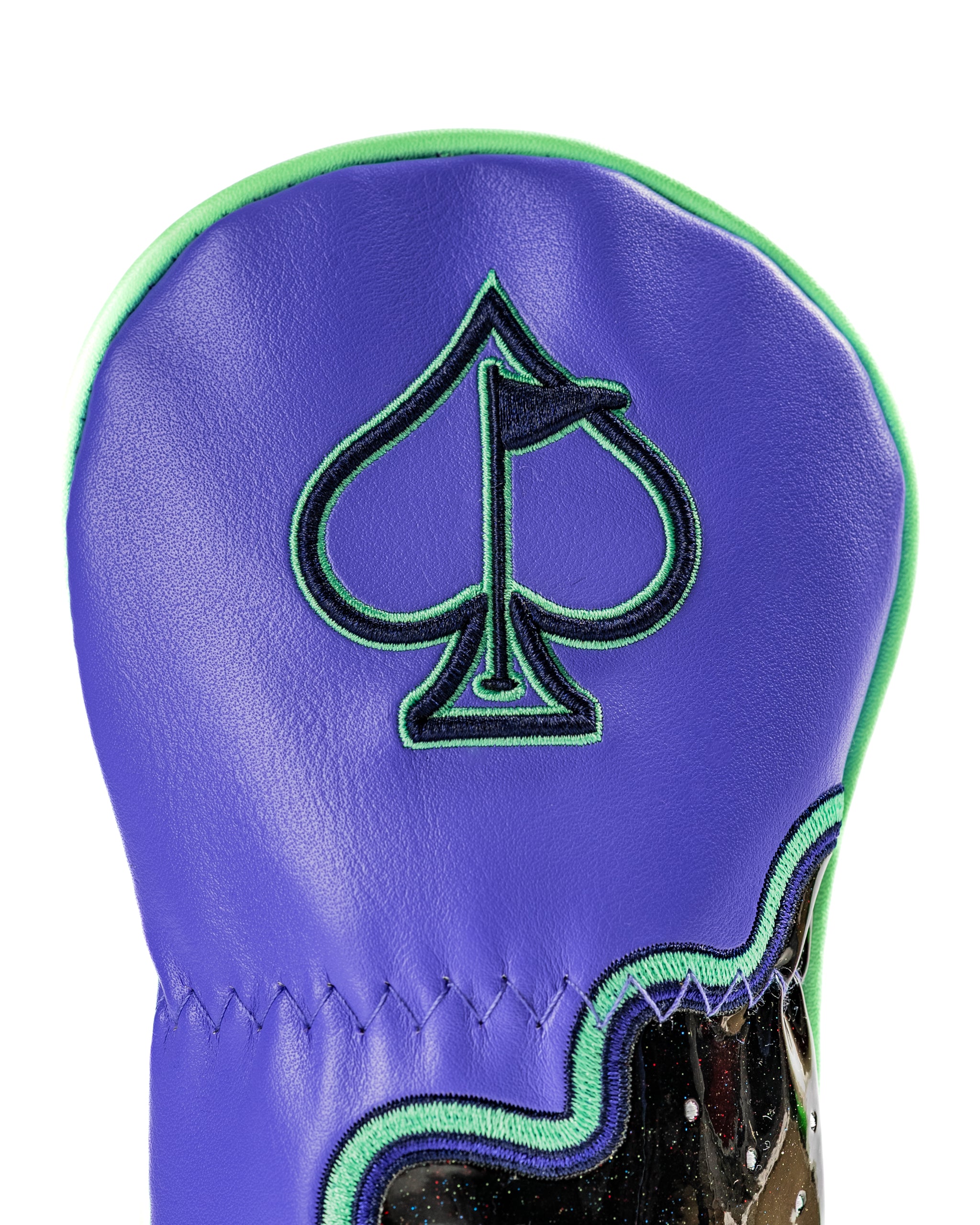 Bold purple hybrid golf cover featuring a spade logo and vibrant green trim, designed for standout style on the course.