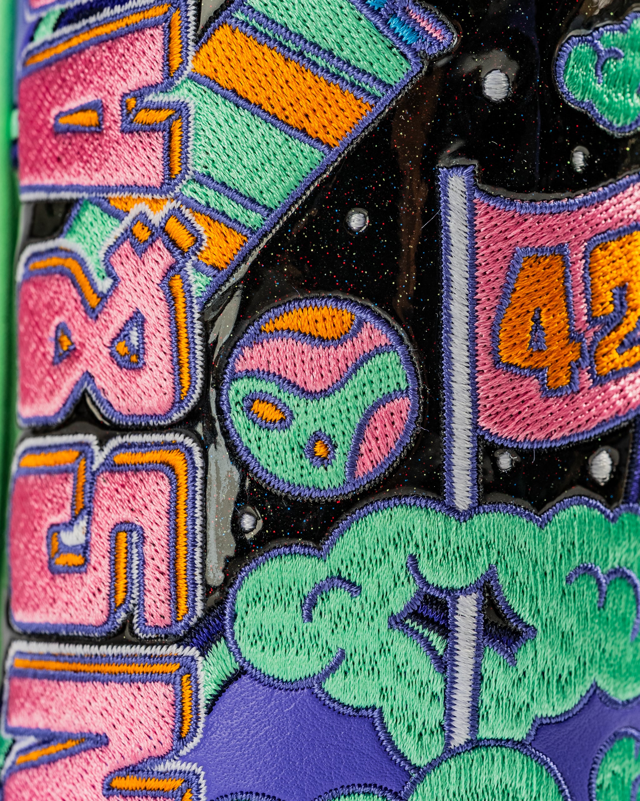 Colorful hybrid golf cover featuring vibrant embroidery of planets, stars, and playful text, designed for bold golfers.
