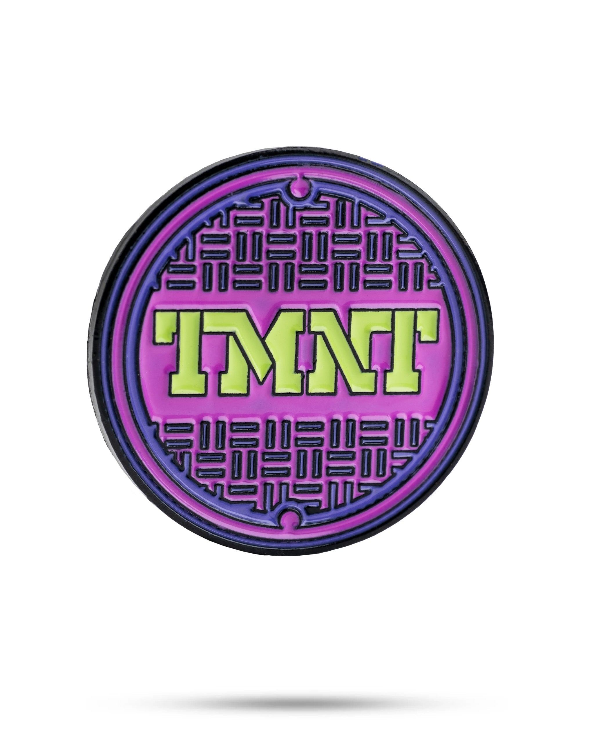 TMNT sewer cover ball marker featuring a vibrant purple and green design with the TMNT logo, perfect for golf enthusiasts.