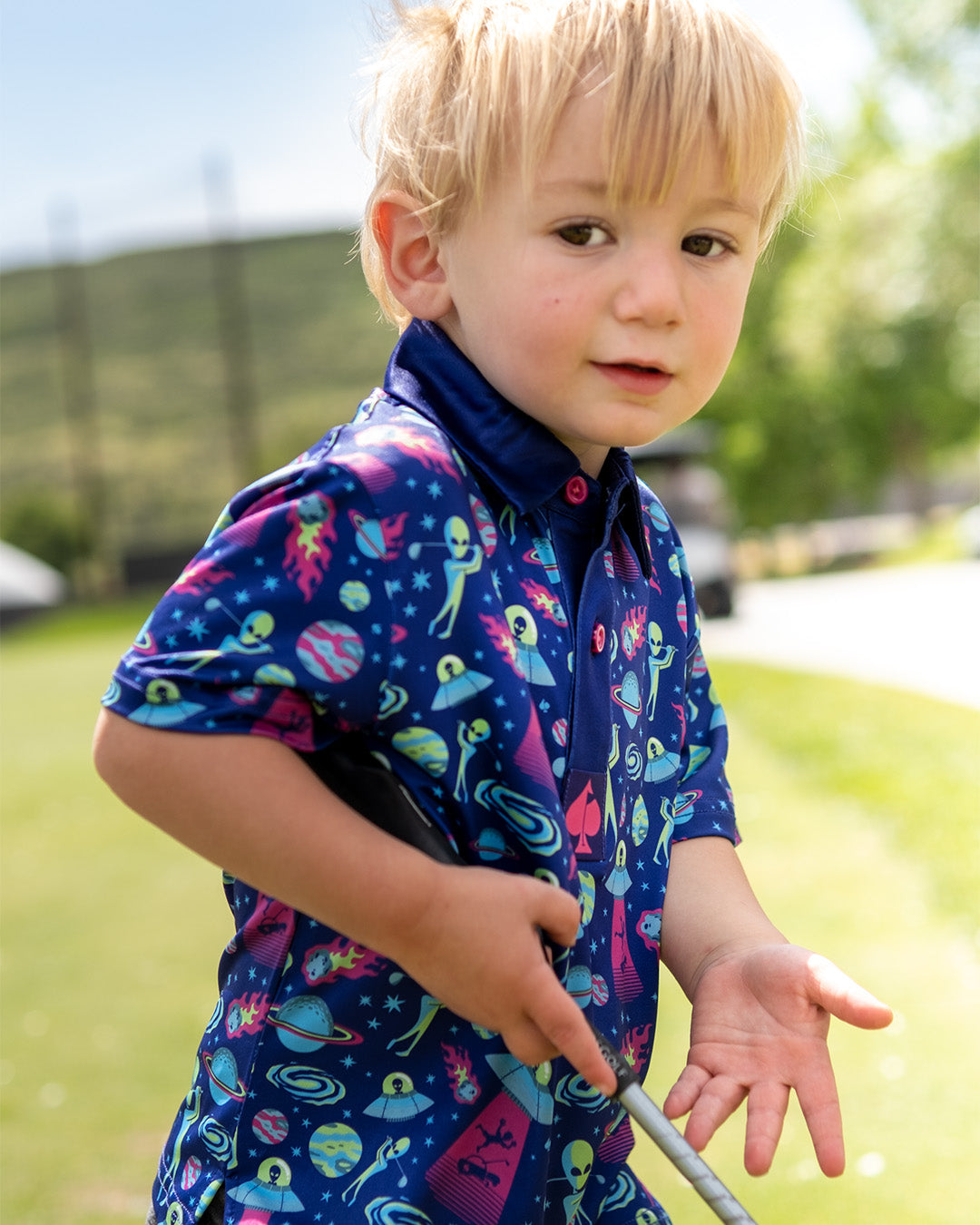 Youth Alien Invasion Polo featuring vibrant space-themed graphics, perfect for young golfers who want to stand out on the course.