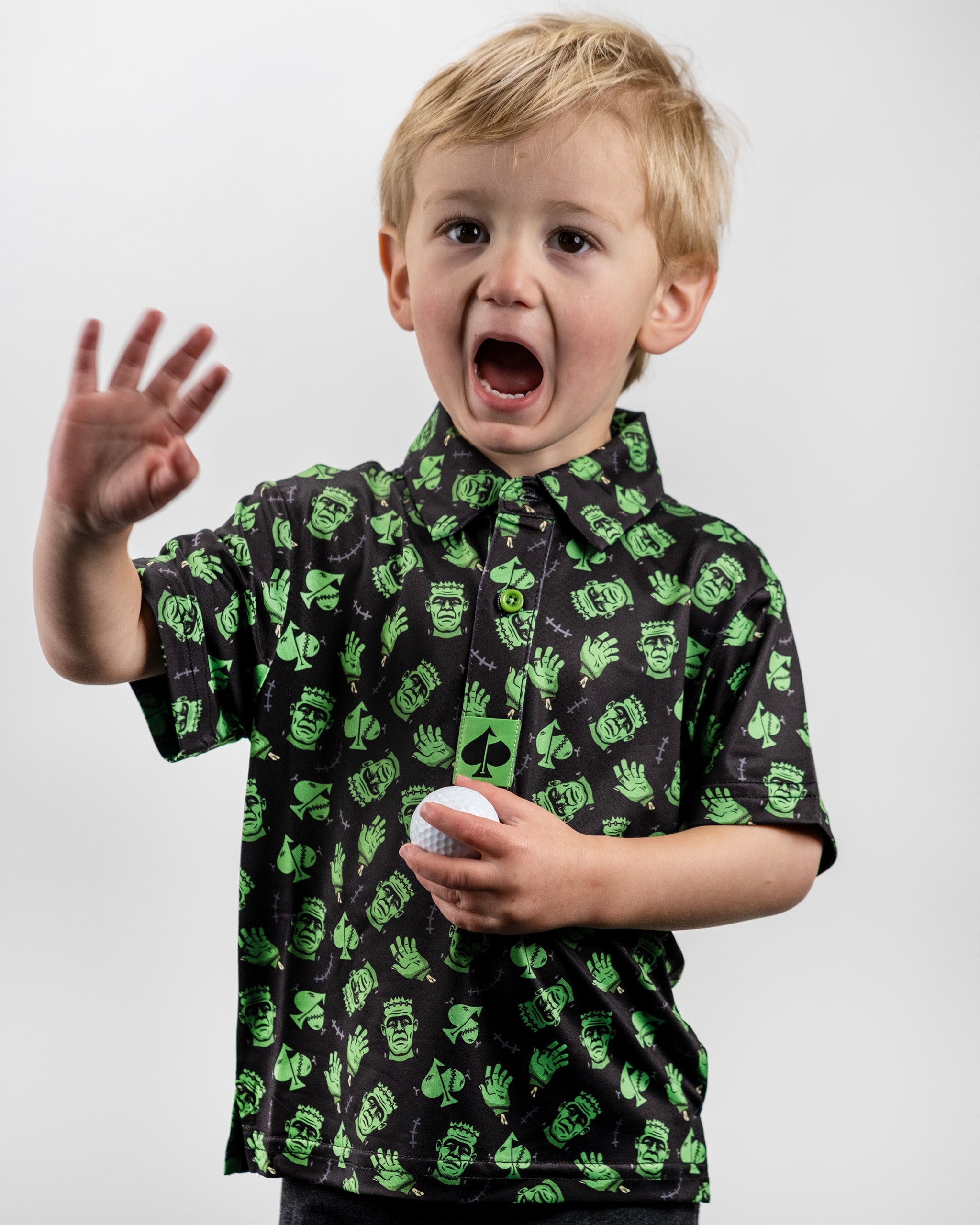 Youth Frankenstein Polo featuring a playful green and black design with cartoon monster motifs, perfect for young golfers.