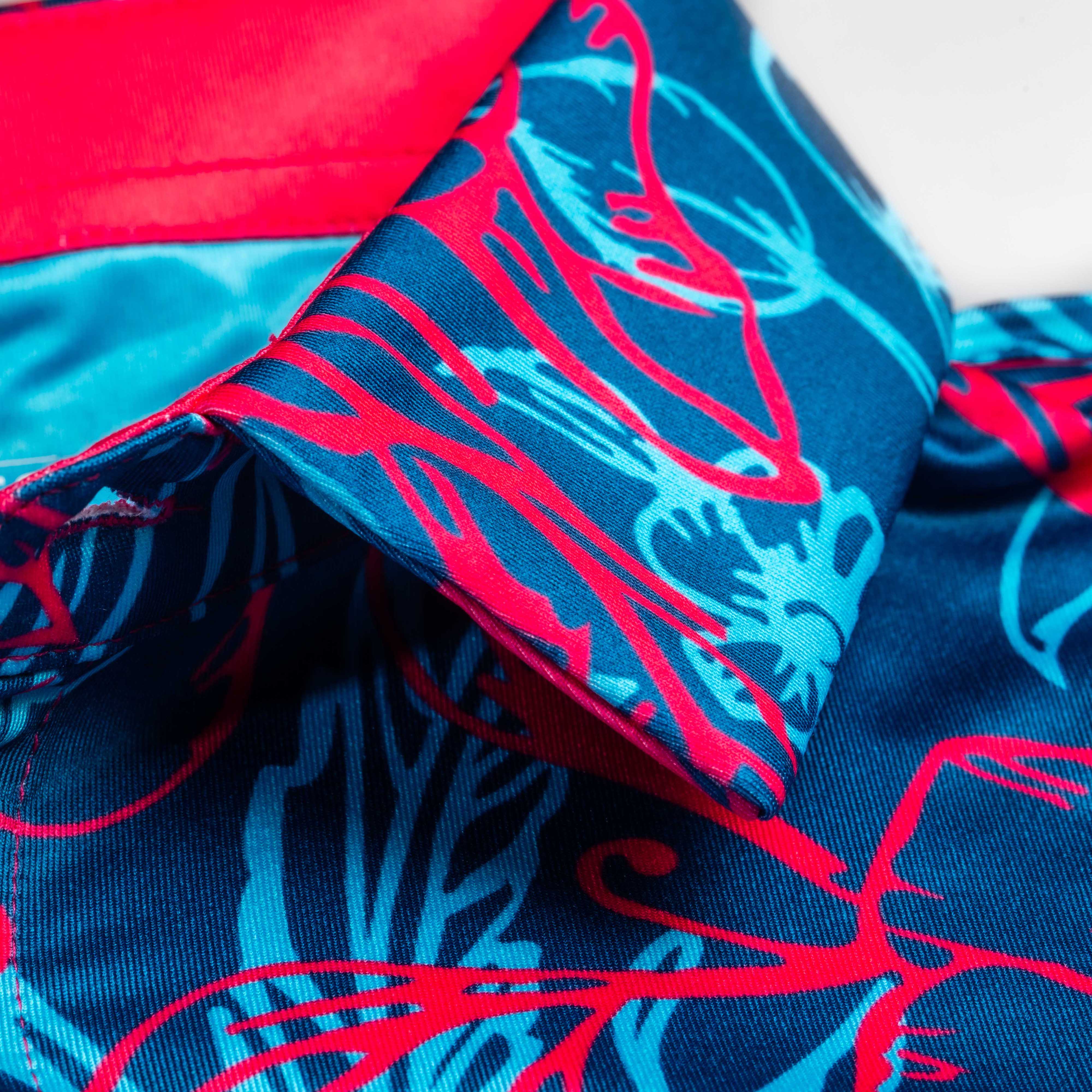 Bold blue and pink Cabo Colada golf shirt featuring vibrant tropical patterns and a stylish collar design.