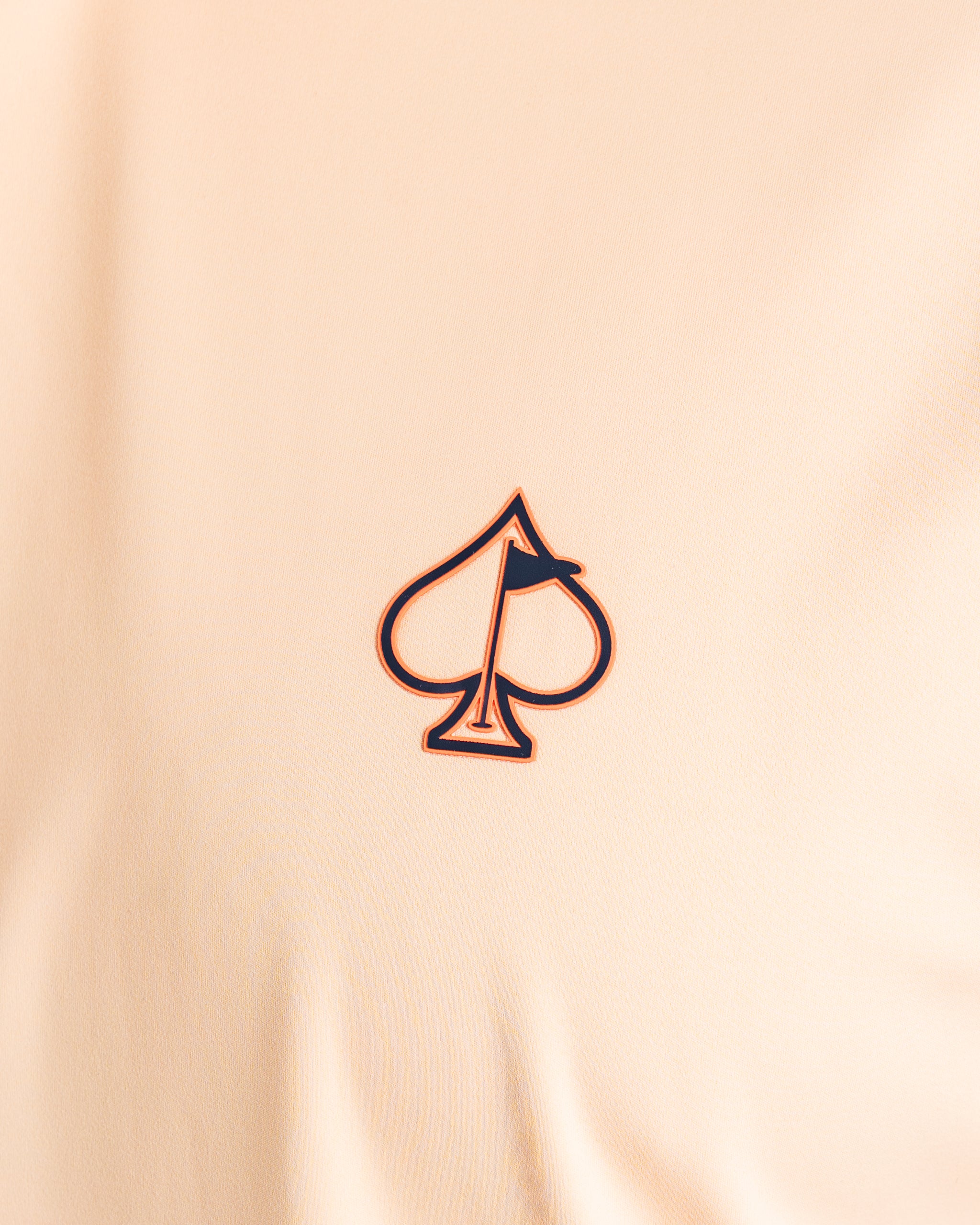 Close-up of the Performance Golf Hoodie in Autumn Leaves featuring a spade logo with a flag design.
