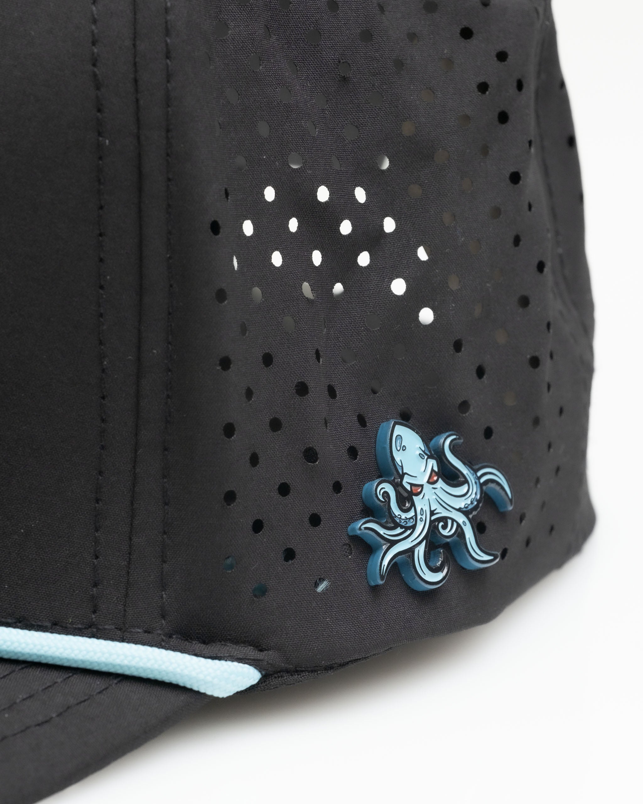 Black golf cap from the Kraken Collection Bundle featuring a blue octopus logo and perforated design for breathability.