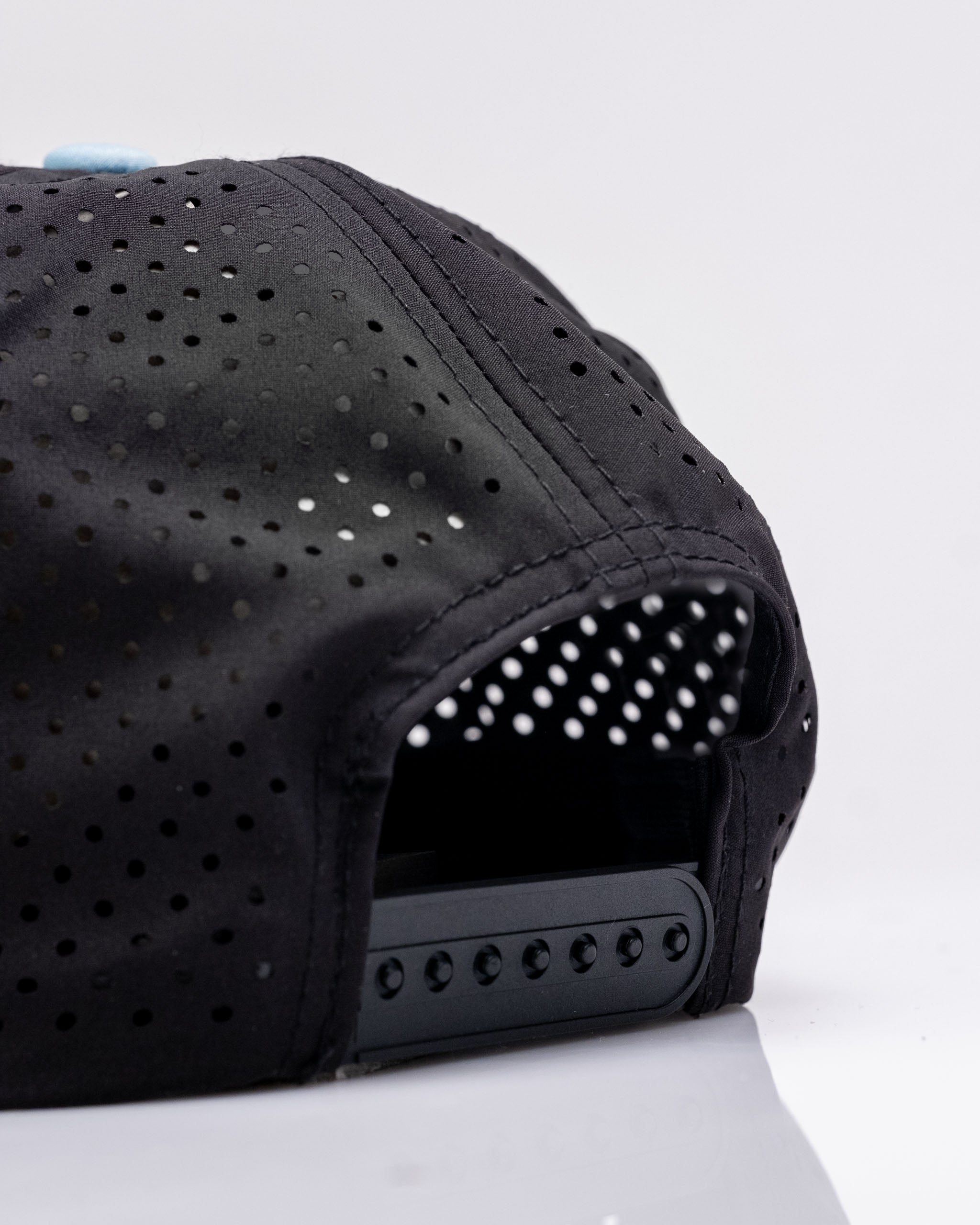 Perforated black rope hat with a stylish design, featuring ventilation holes for breathability and comfort.