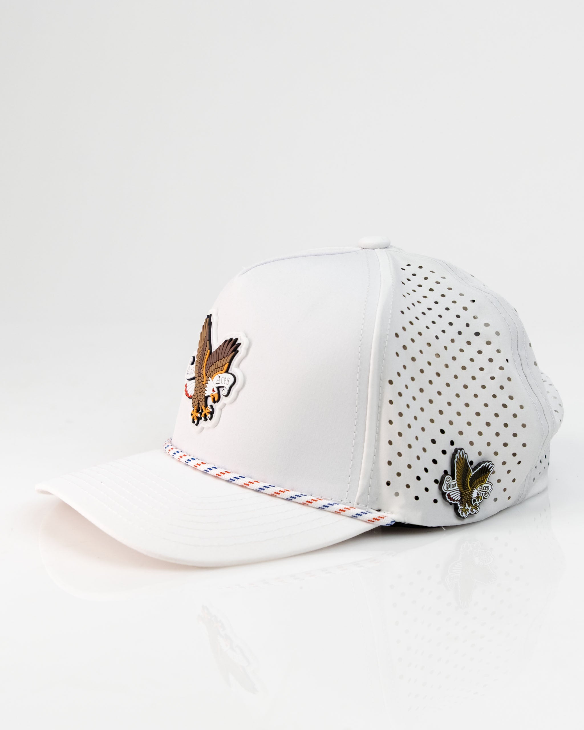 White perforated rope hat featuring an eagle design and colorful detailing, perfect for stylish golfers.