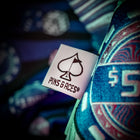 Close-up of the Pins and Aces logo on a colorful fabric, showcasing the unique design of the Mystery Box Backpack.