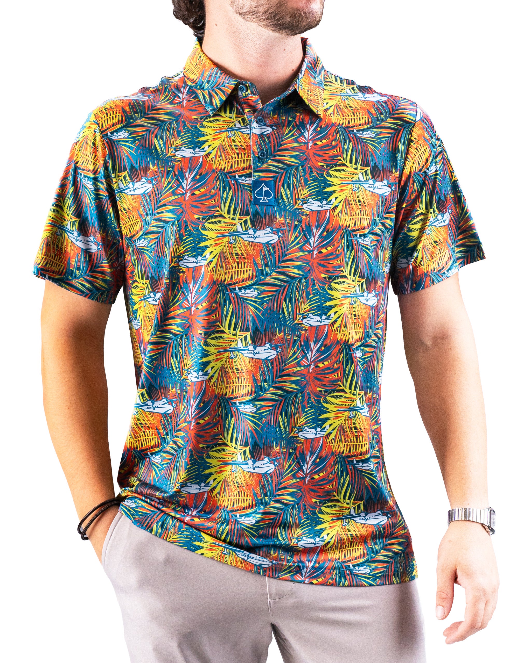 Bright tropical-patterned golf shirt with colorful leaves and small white boats, perfect for bold, standout golf style.