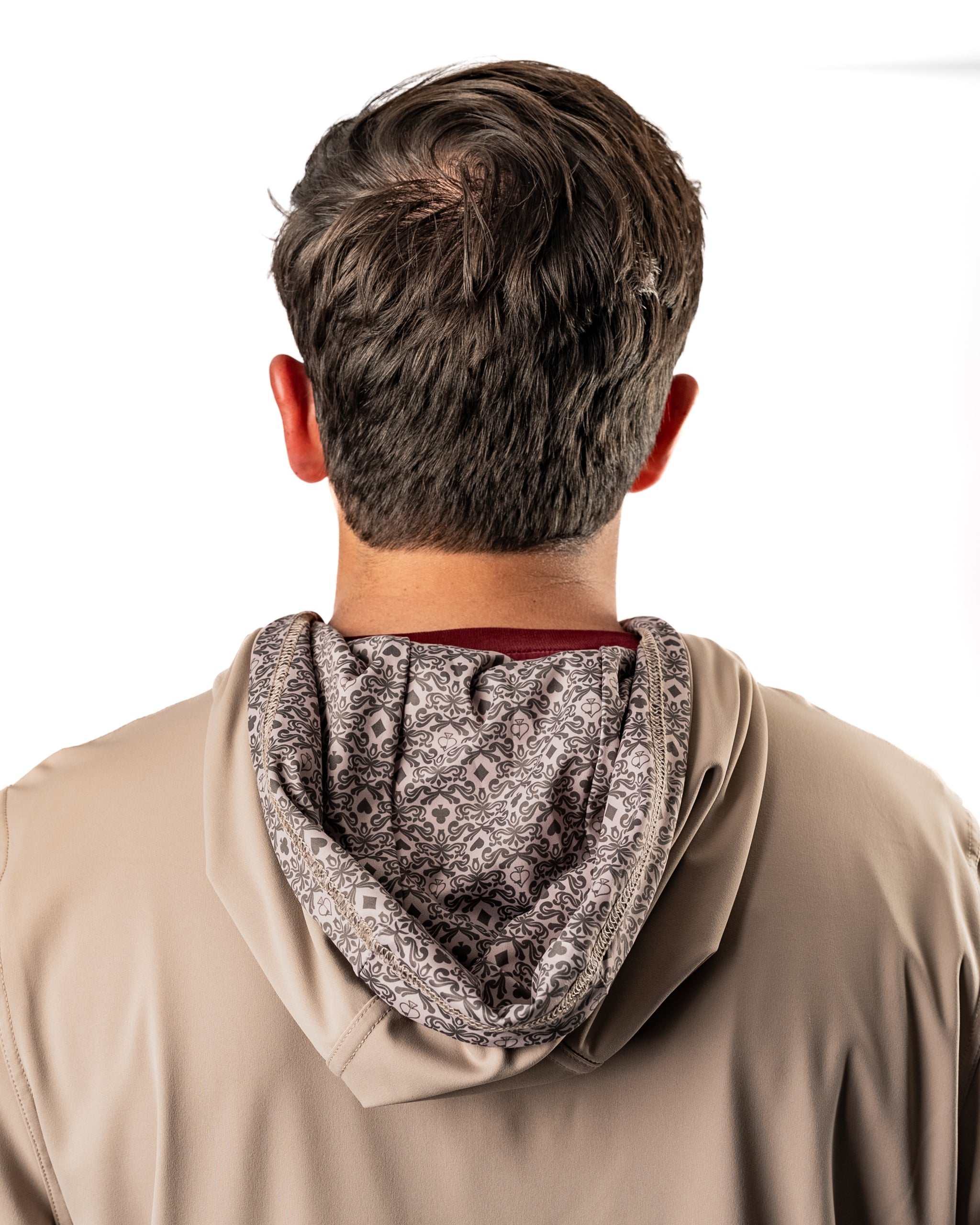 Back view of a man wearing a Performance Golf Hoodie in Big Blind Ash, showcasing the patterned interior of the hood.