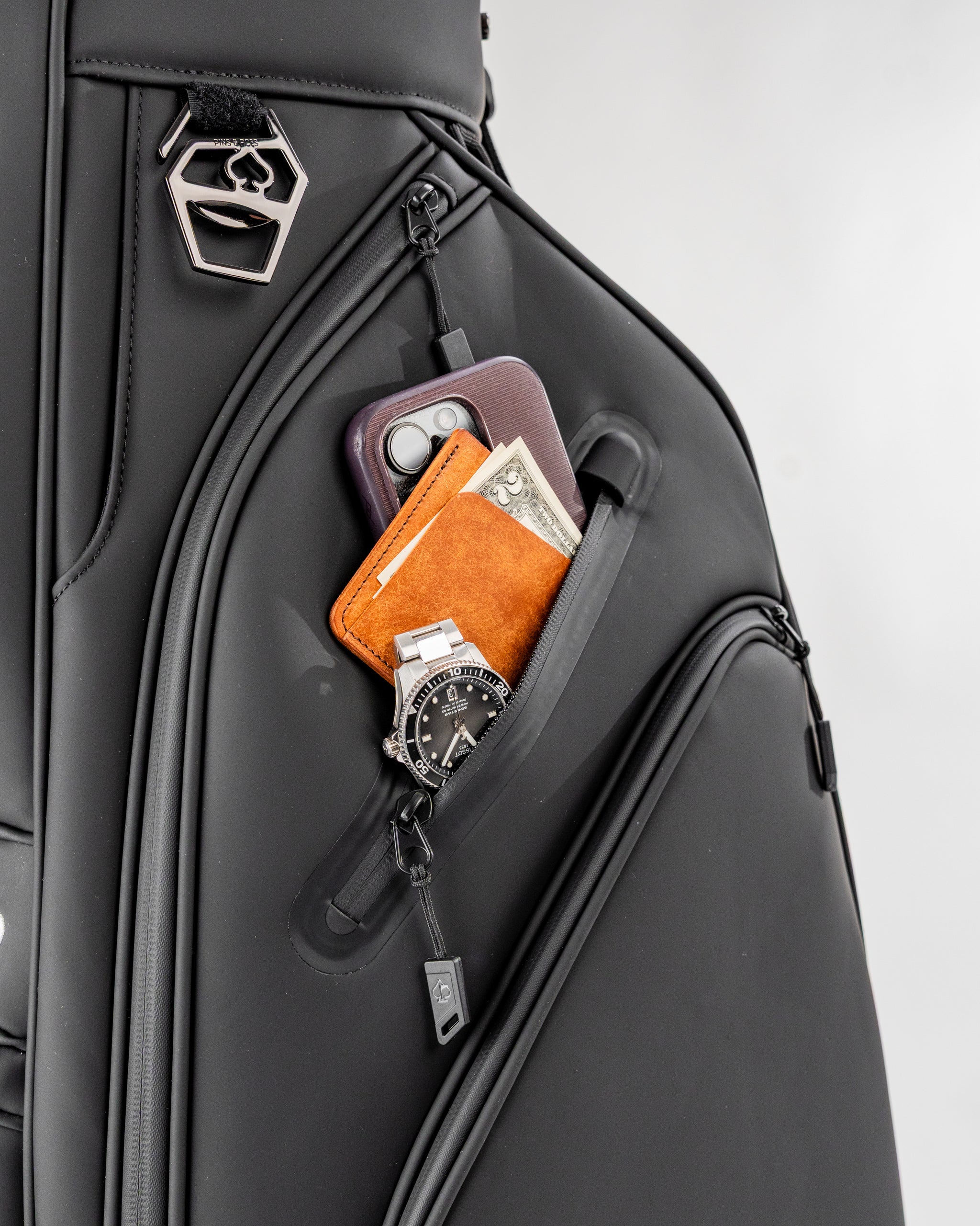 Black Player Preferred Cart Bag featuring a zippered pocket holding a phone, wallet, cash, and watch for golfers.