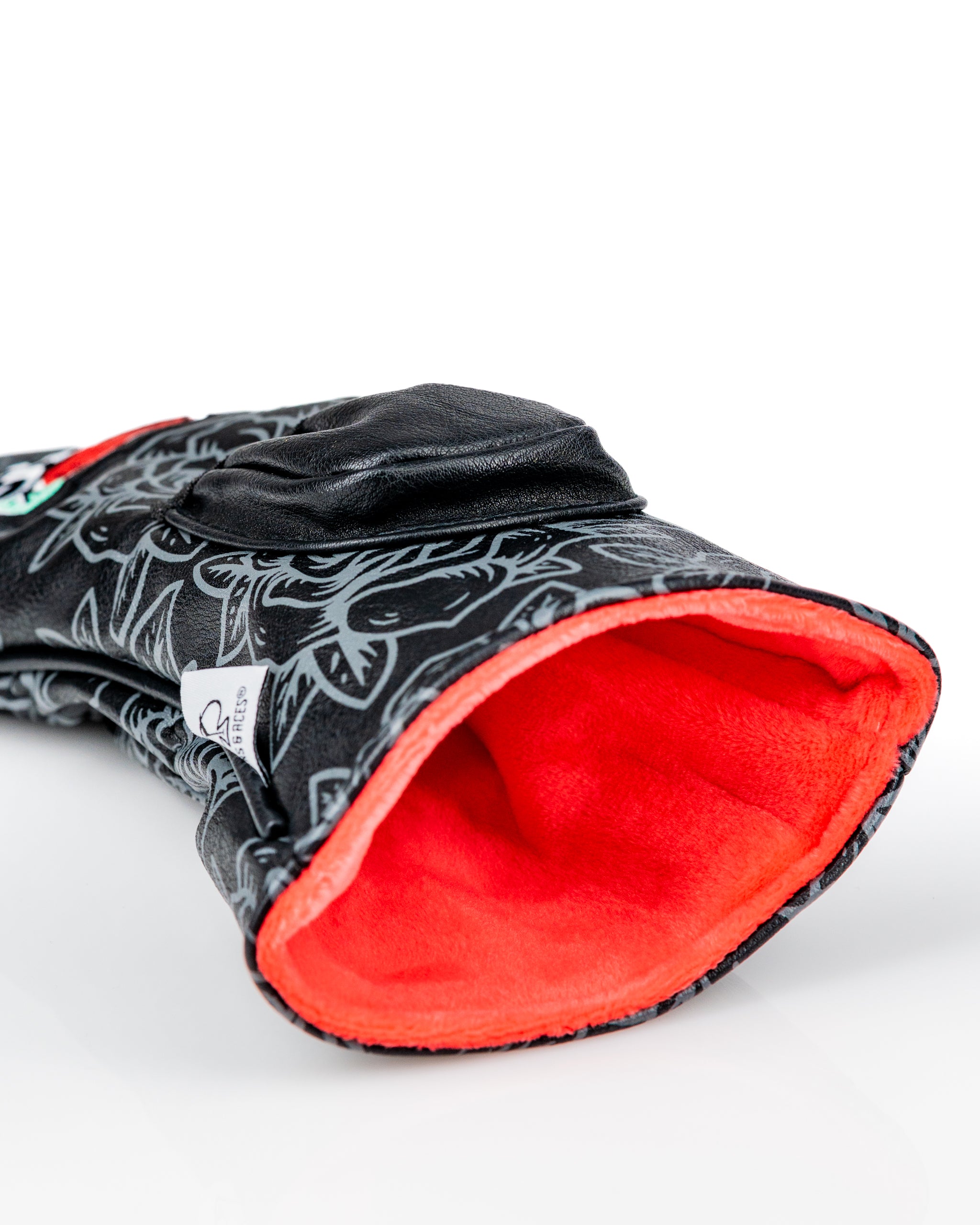 Bold black driver cover featuring intricate floral patterns and a vibrant orange interior, designed for stylish golfers.